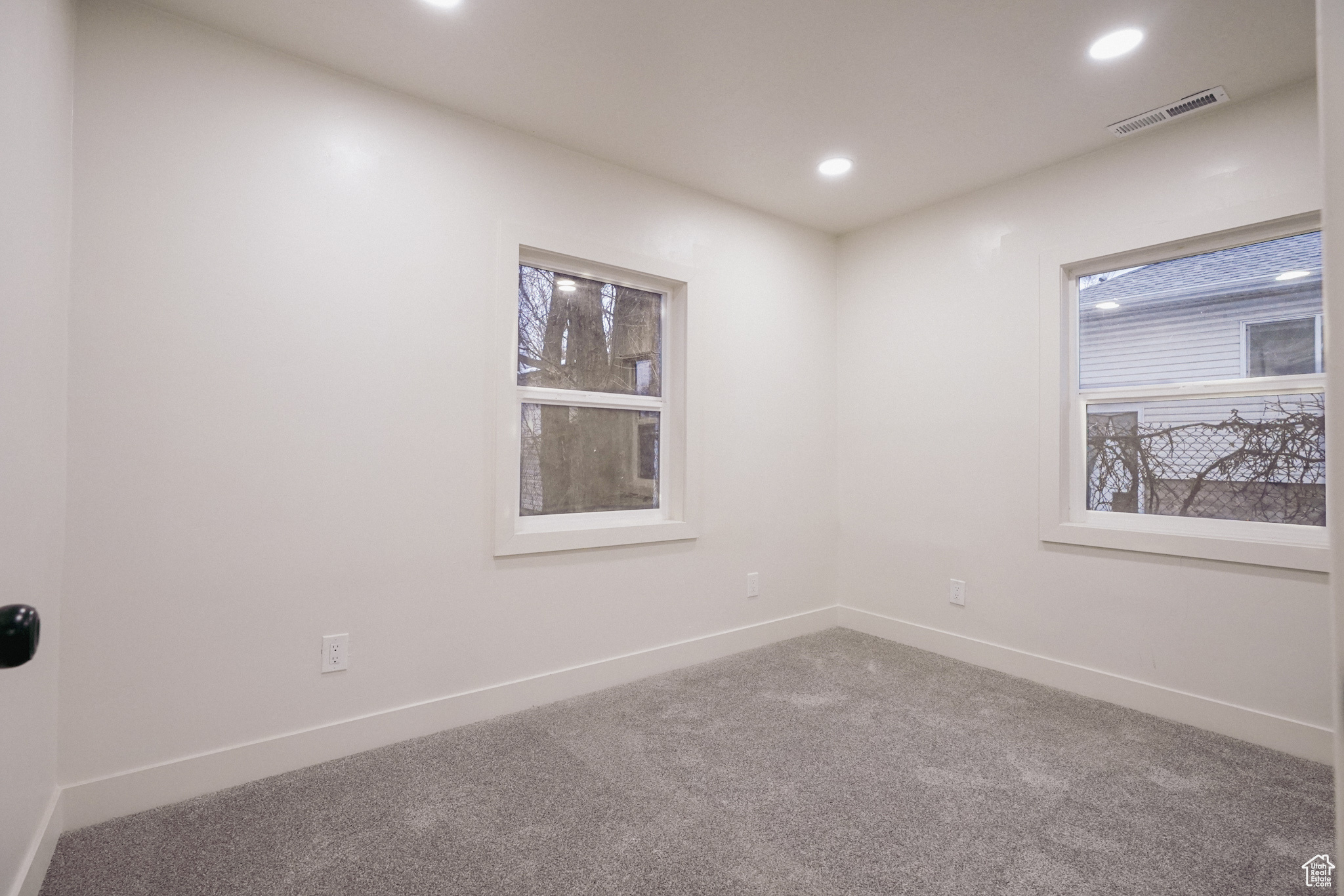 Spare room featuring carpet floors, recessed lighting, visible vents, and baseboards