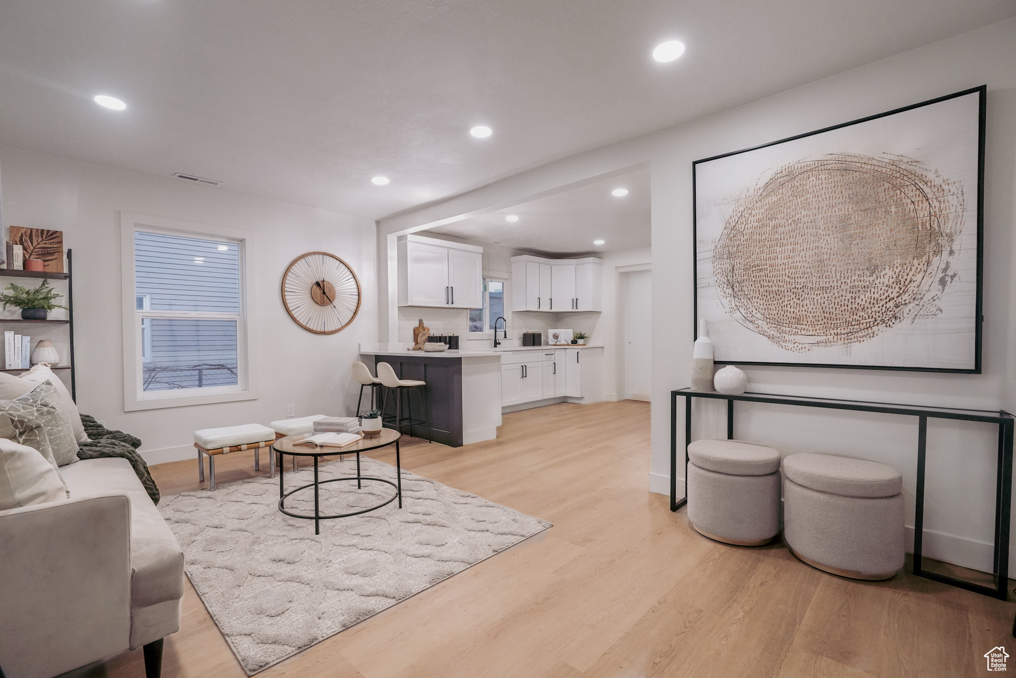 Living area with light wood-type flooring, baseboards, and recessed lighting