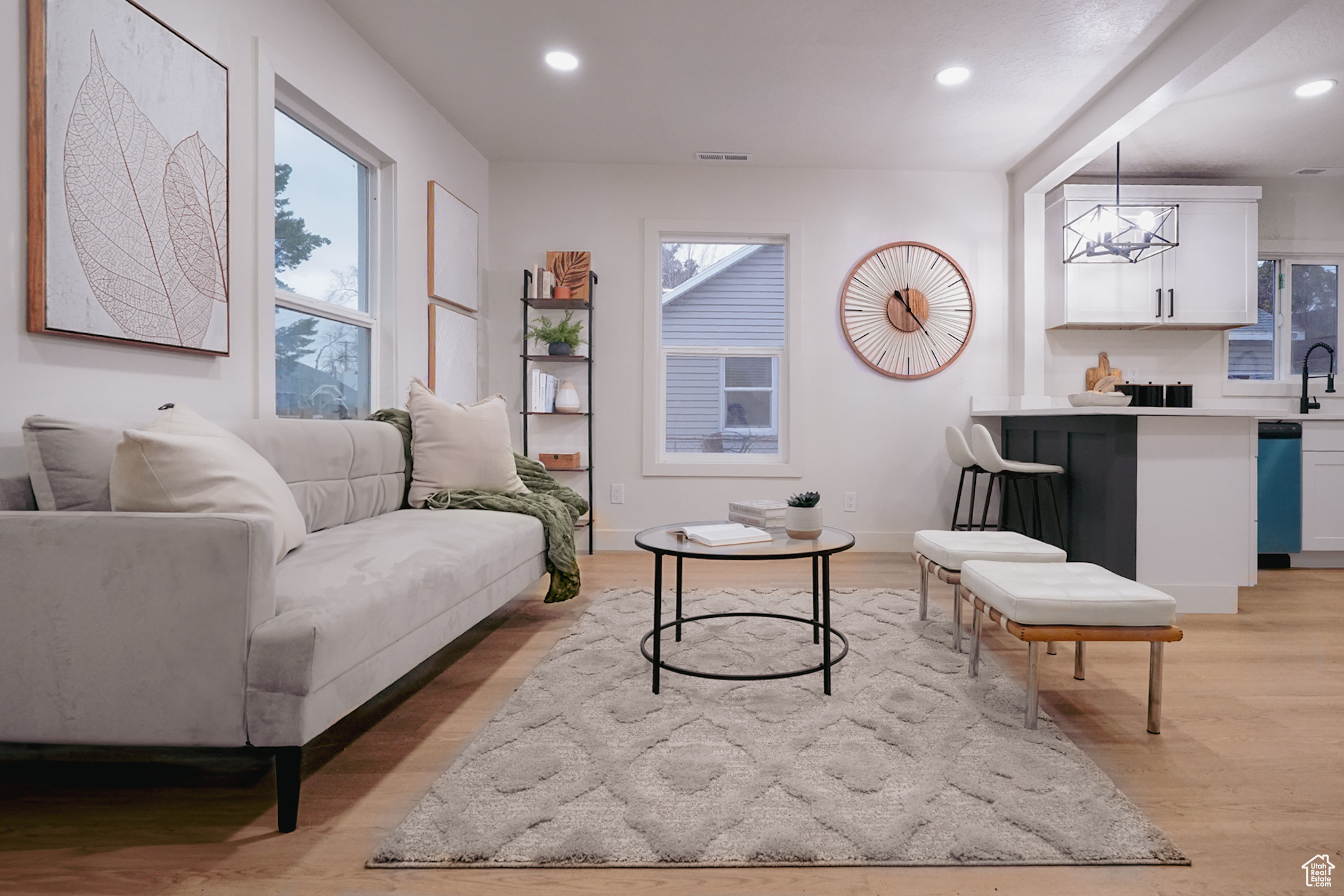 Living area featuring recessed lighting, visible vents, baseboards, light wood-type flooring, and an inviting chandelier