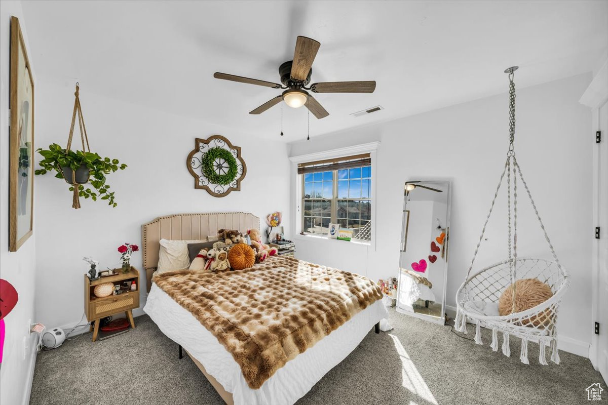 Bedroom featuring a ceiling fan, baseboards, visible vents, and carpet flooring