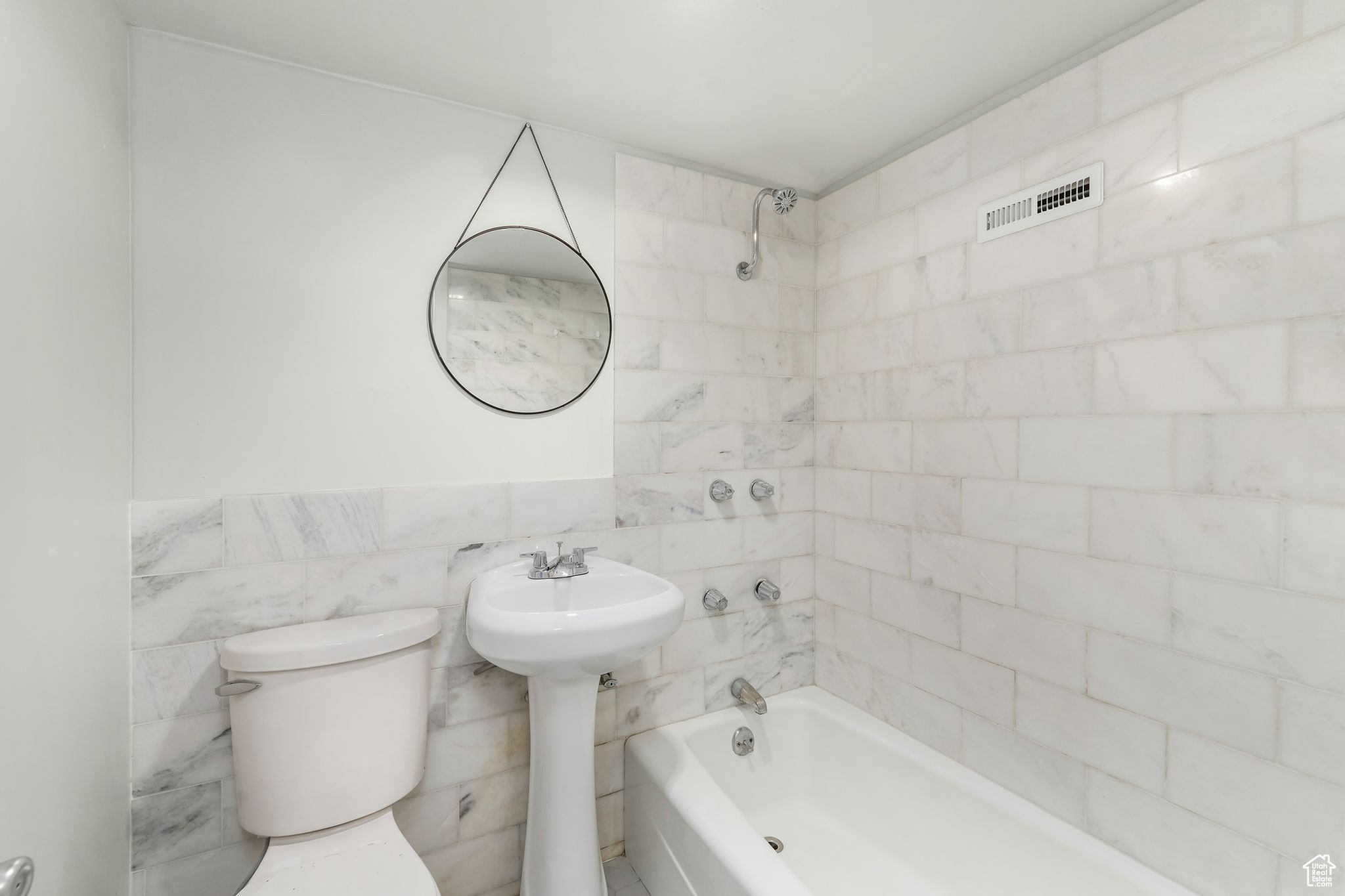 Bathroom with visible vents, tile walls, toilet, and bathing tub / shower combination