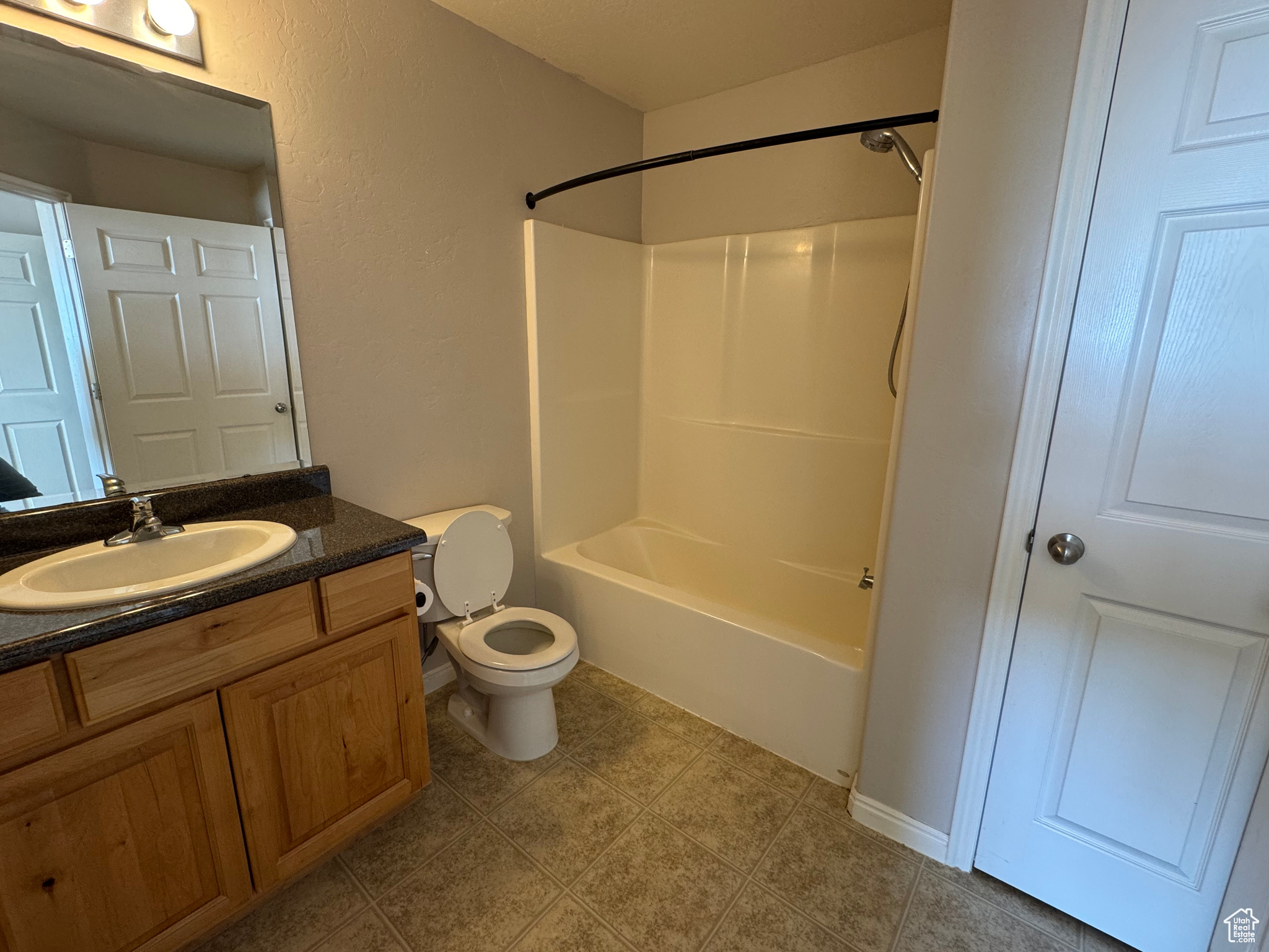 Full bathroom featuring toilet, tile patterned floors, bathing tub / shower combination, and vanity