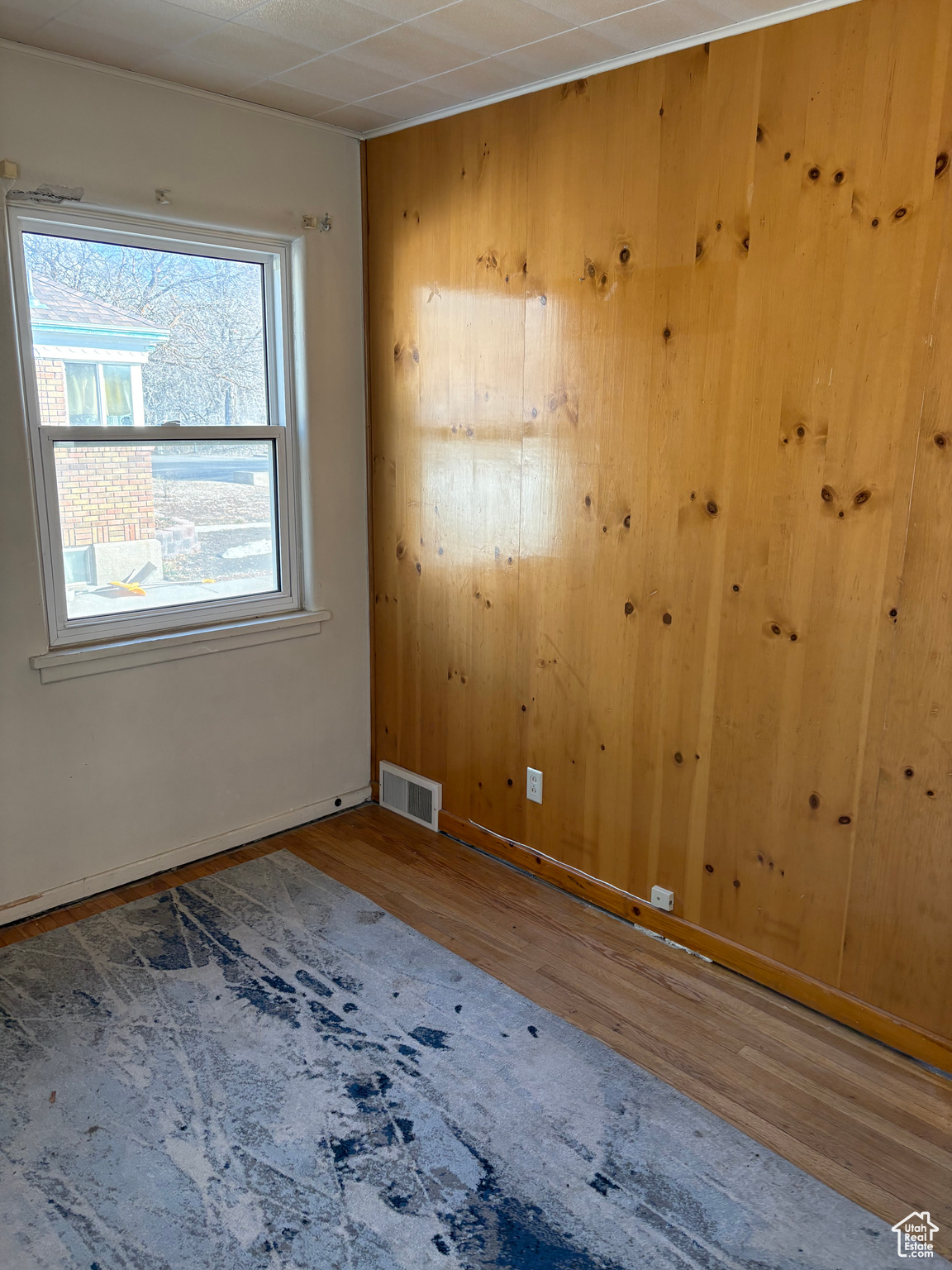 Unfurnished bedroom with baseboards, visible vents, and wood finished floors