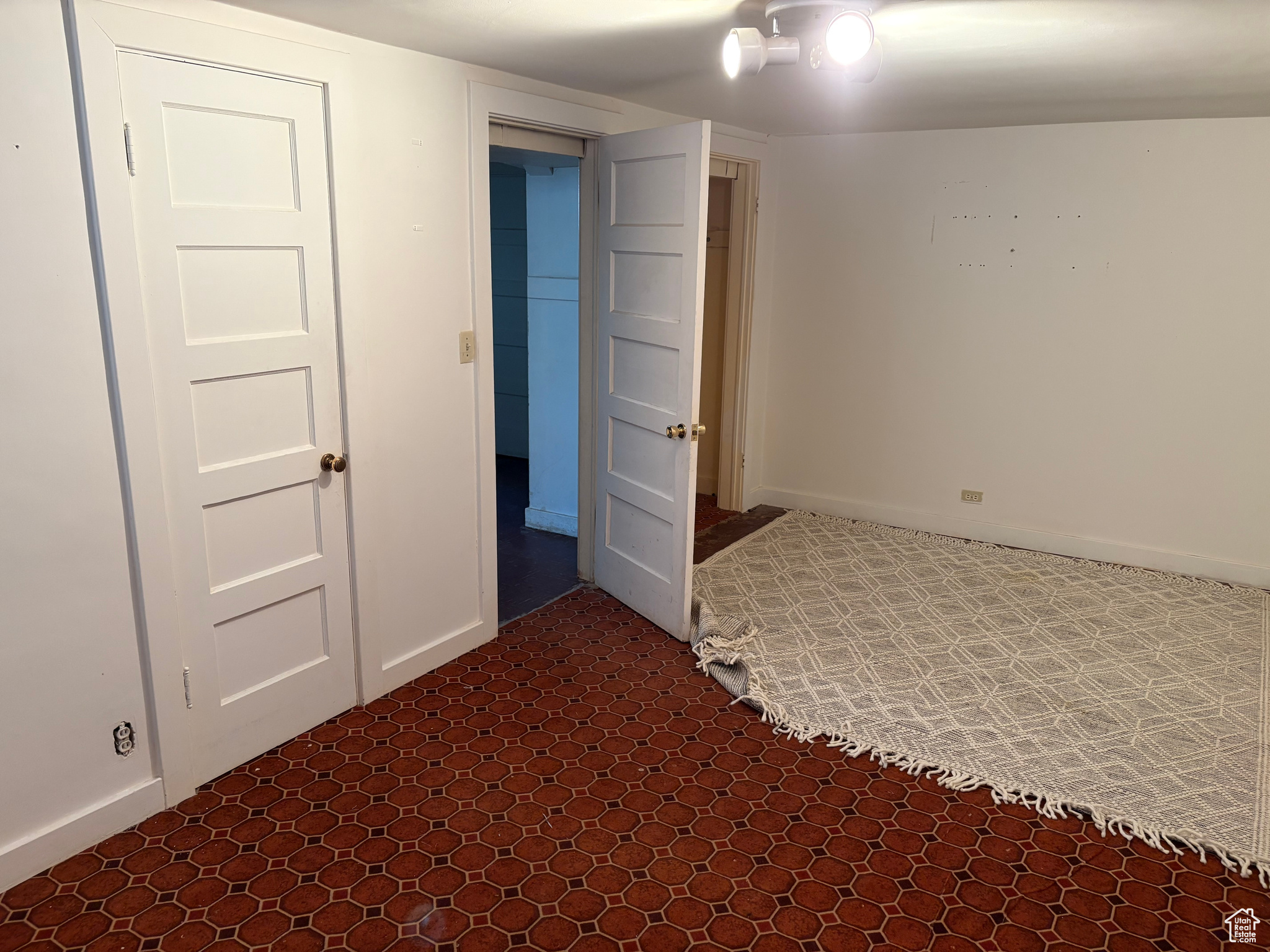Unfurnished bedroom with tile patterned floors, baseboards & two closets