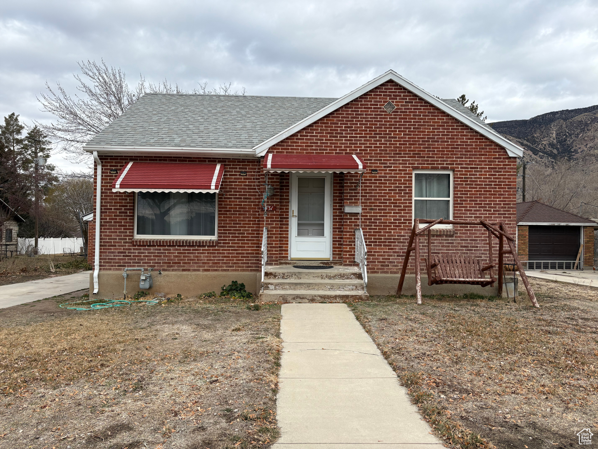 Bungalow-style home featuring roof with shingles and brick siding