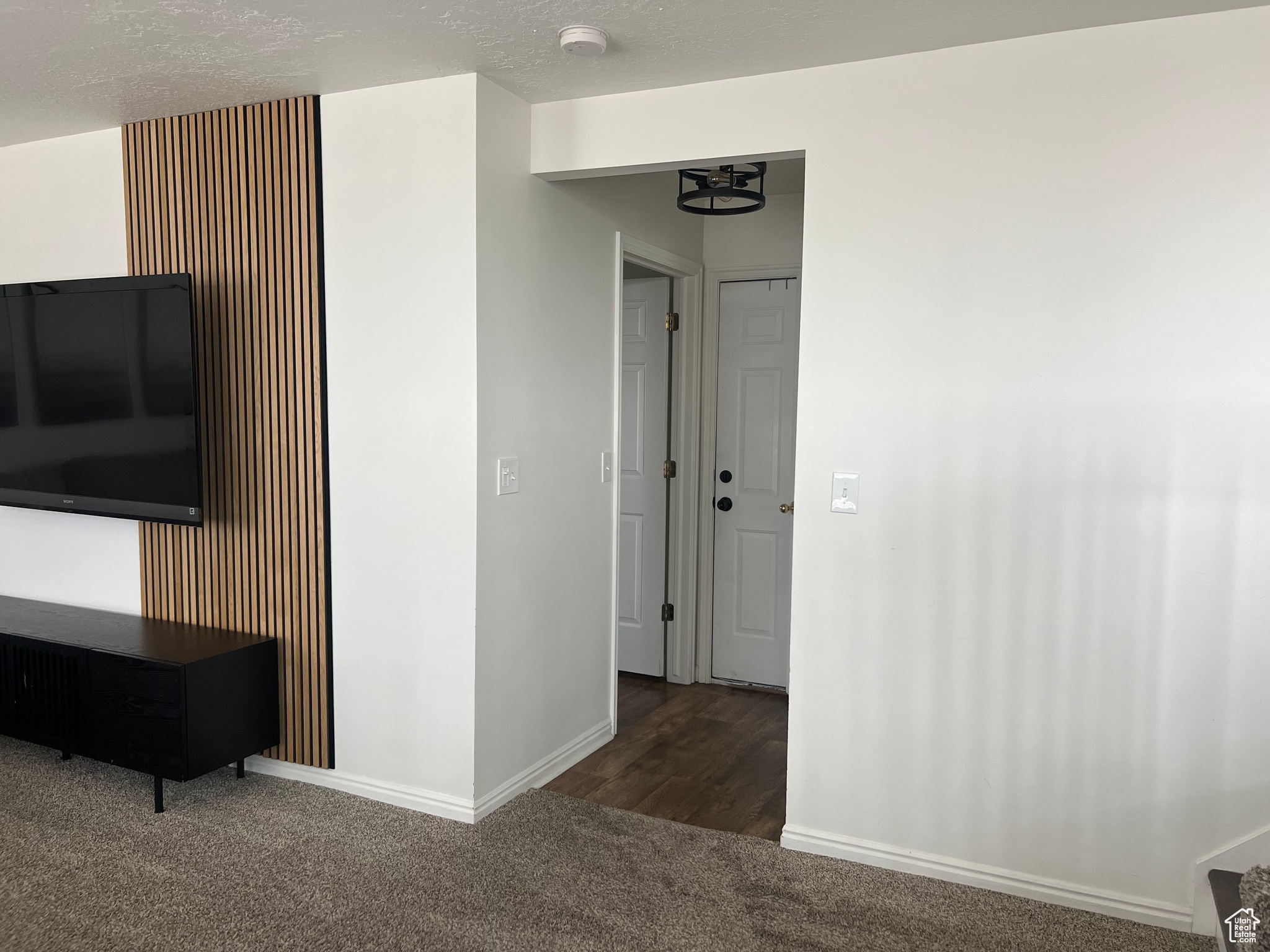 Interior space with baseboards, dark carpet, and a textured ceiling