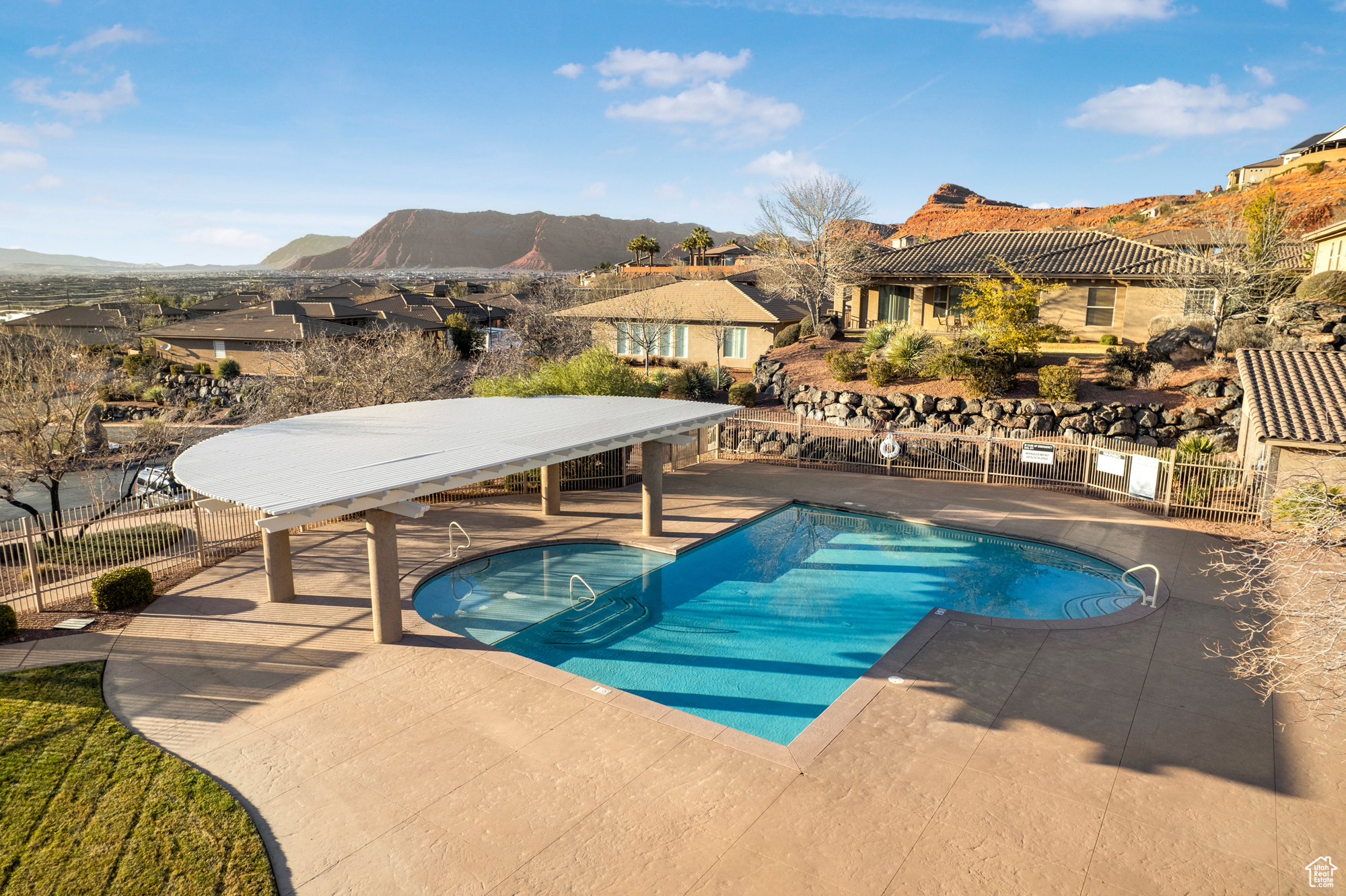 Community pool featuring fence, a mountain view, a patio, and a residential view