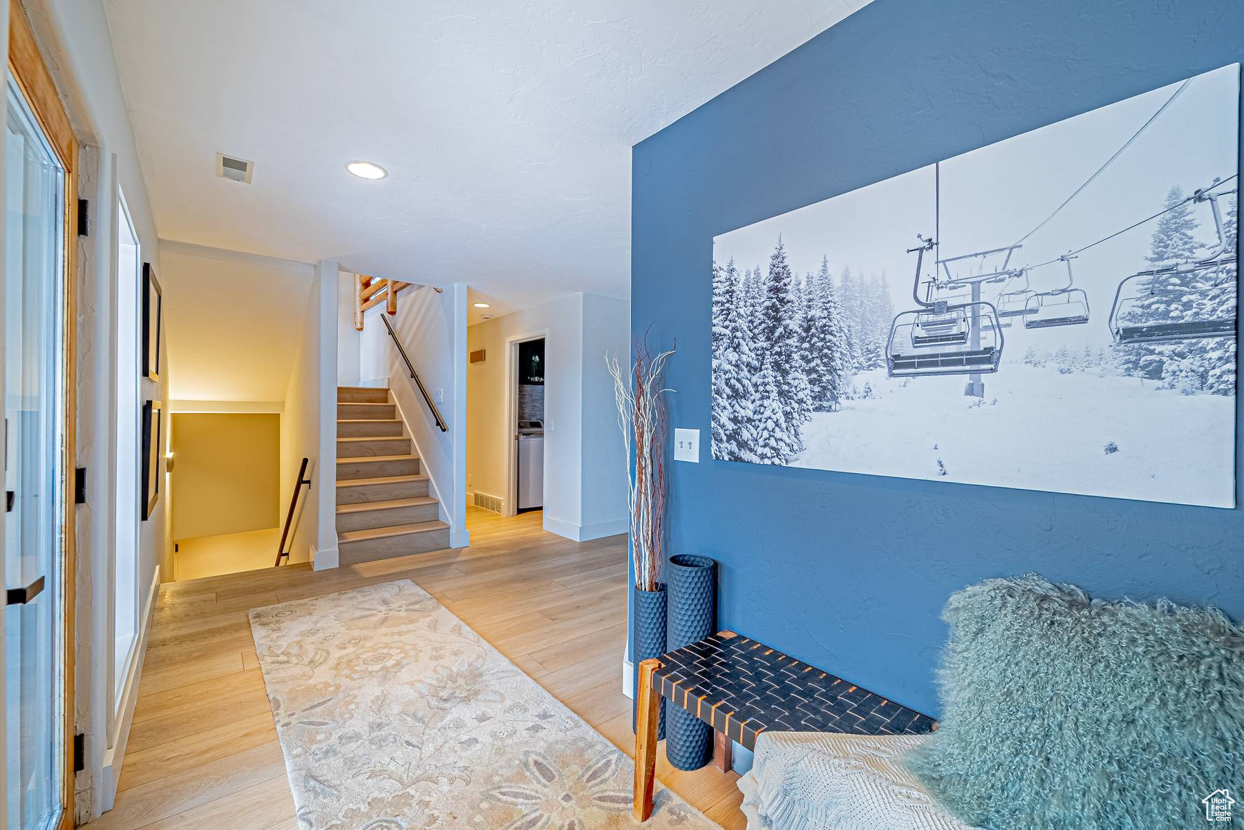 Living area featuring light wood-type flooring, visible vents, stairway, and recessed lighting