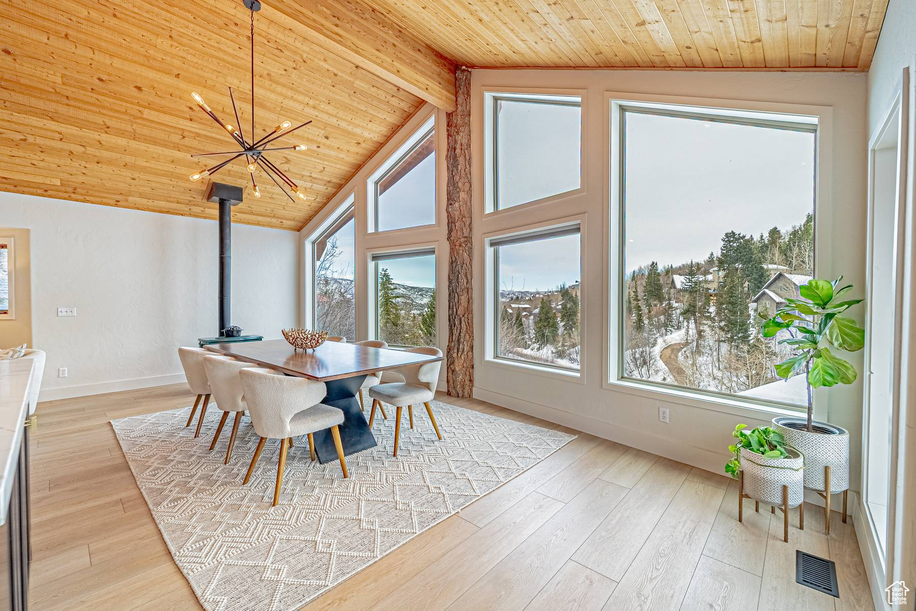 Dining area with a healthy amount of sunlight, light wood finished floors, wood ceiling, and visible vents