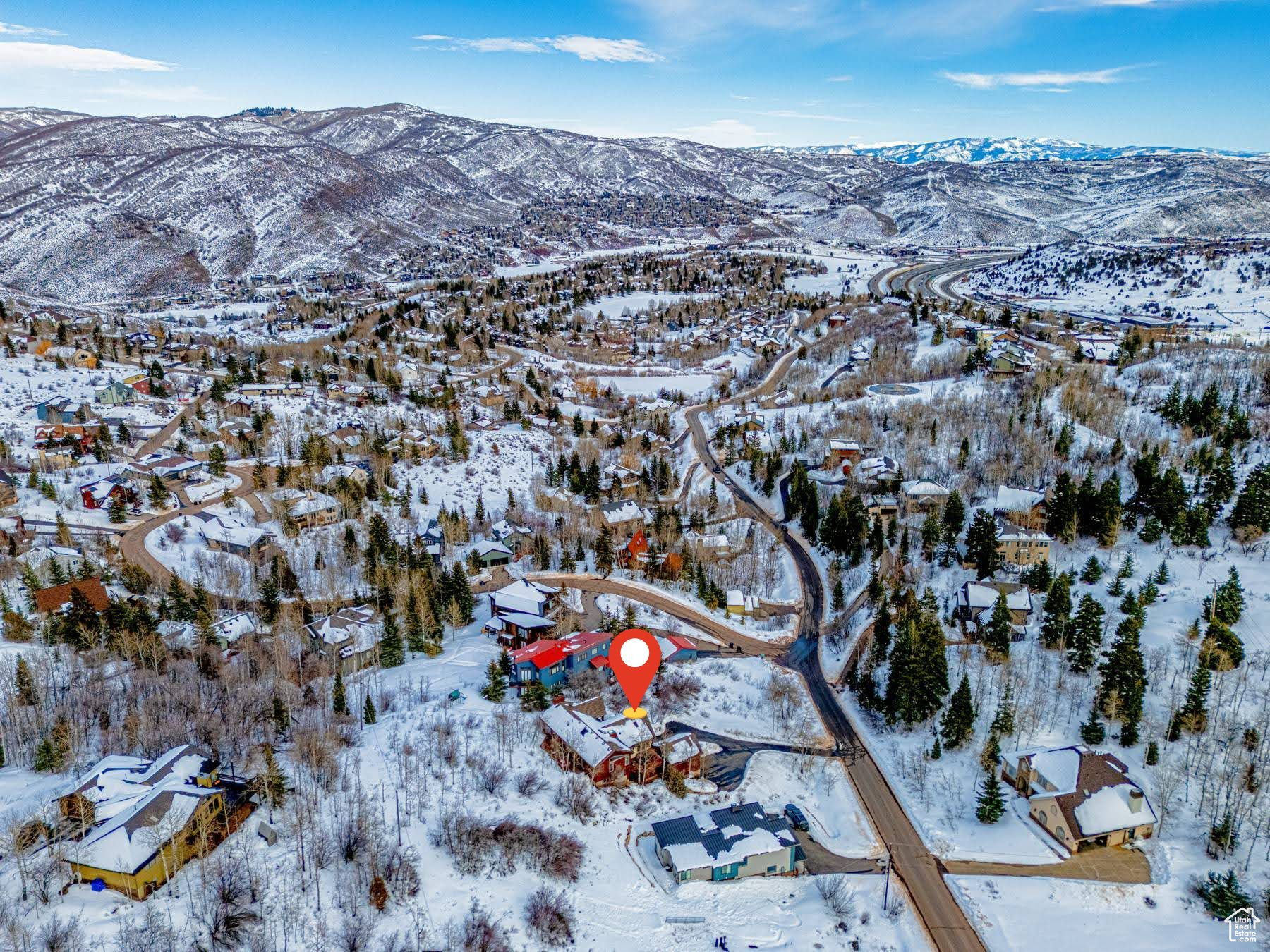 Snowy aerial view featuring a residential view and a mountain view