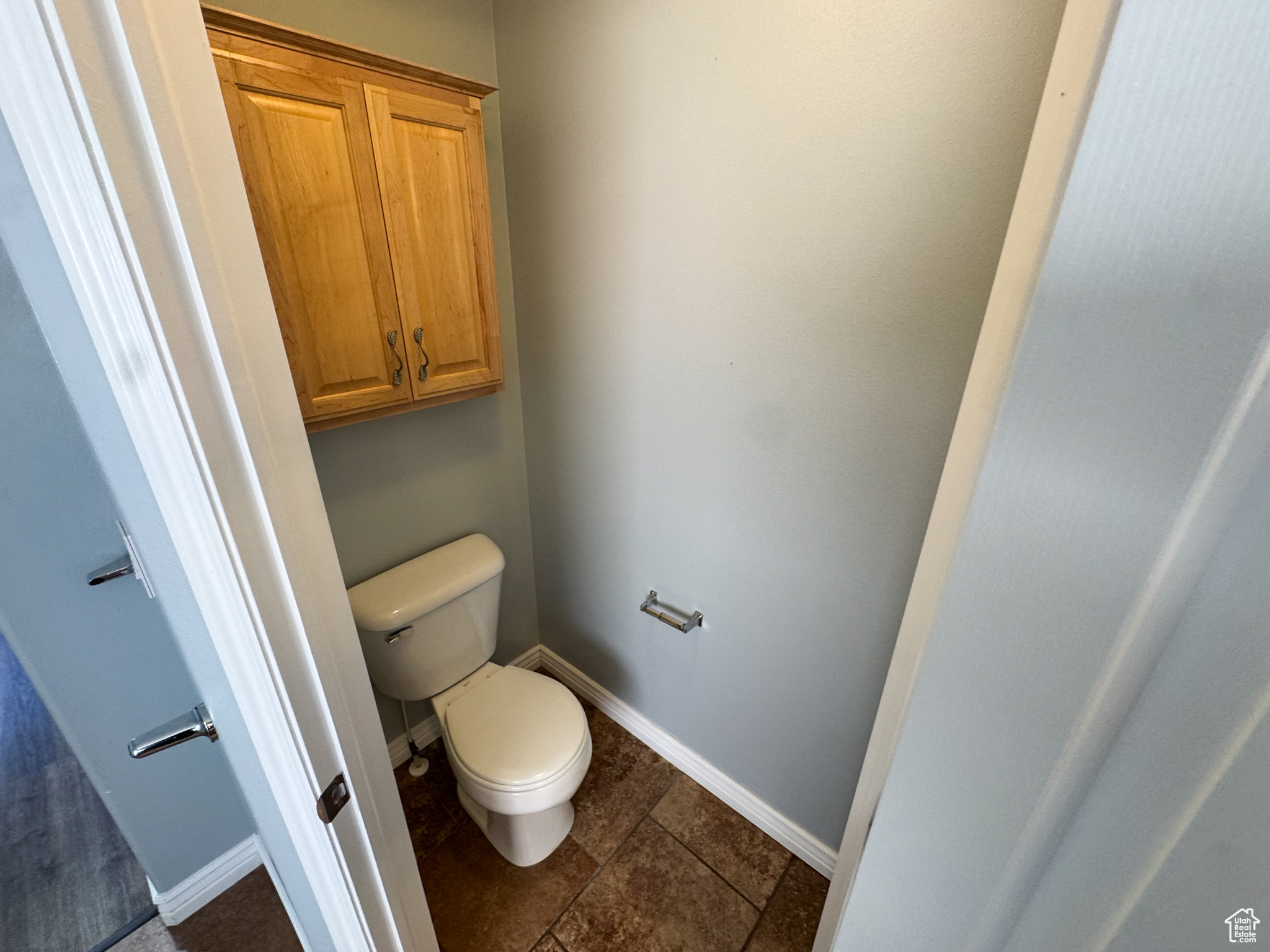 Bathroom with tile patterned flooring, baseboards, and toilet