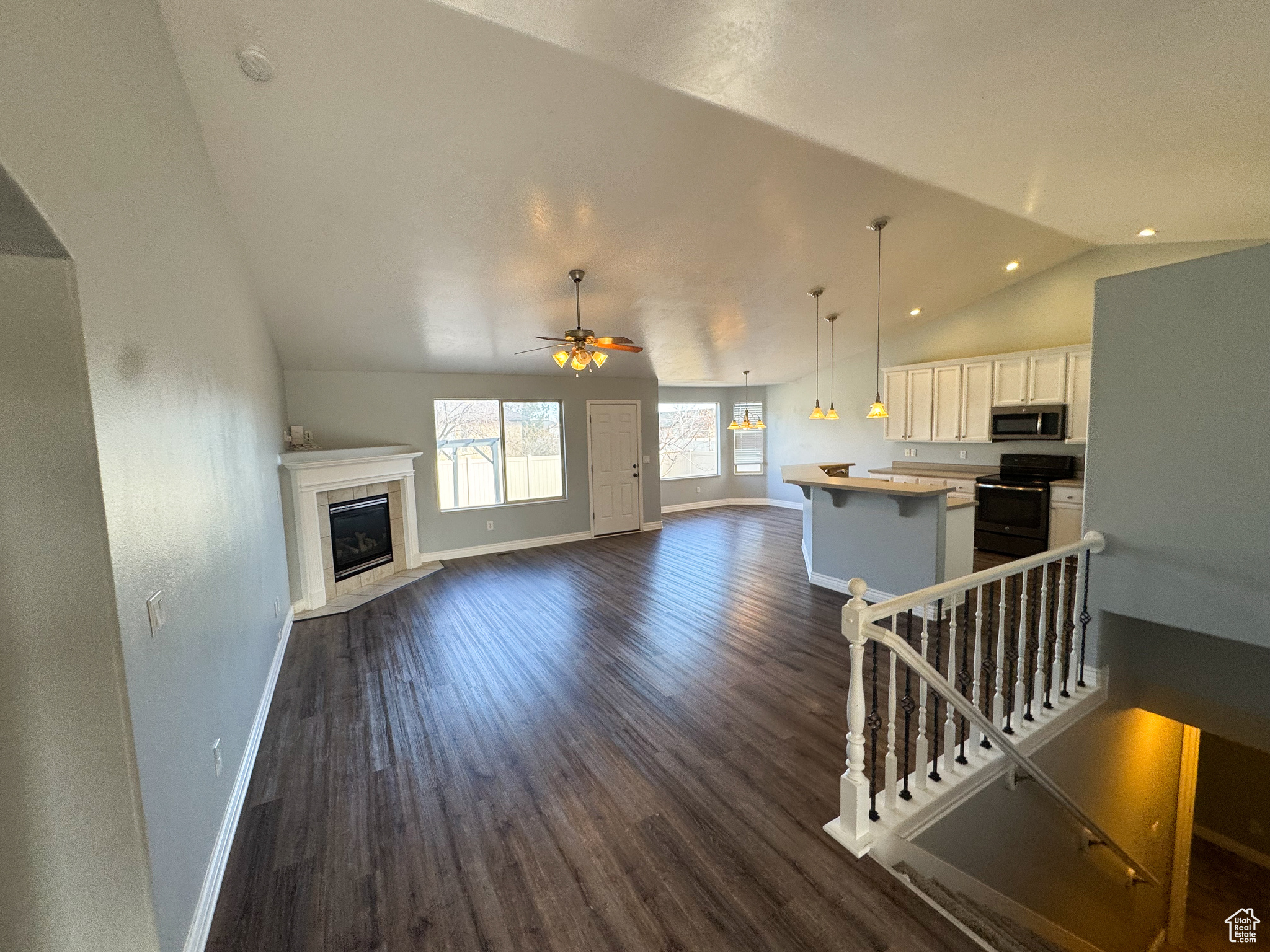 Kitchen with light countertops, stainless steel microwave, open floor plan, white cabinetry, and a kitchen island