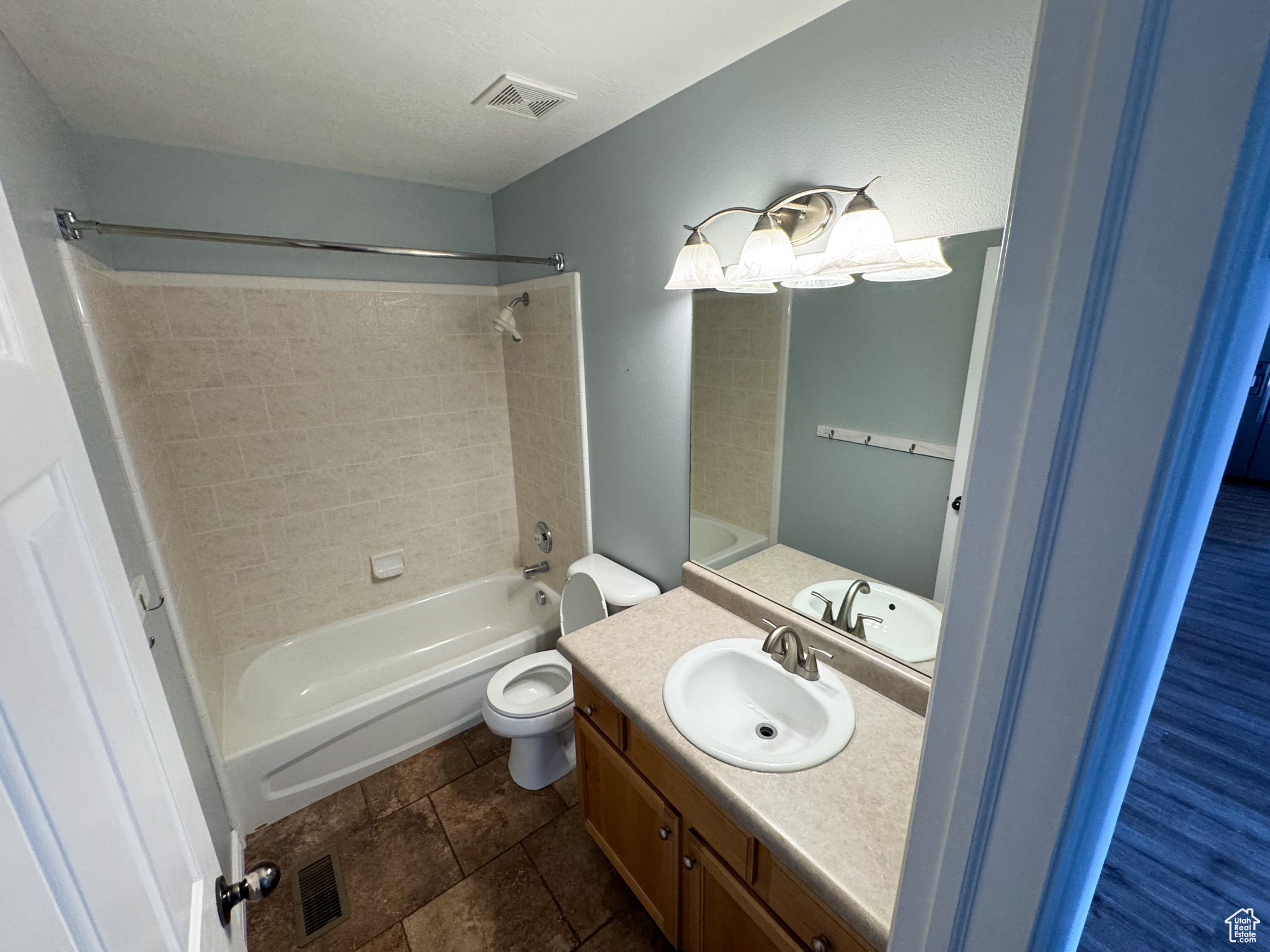 Bathroom with visible vents, vanity, toilet, and shower / bathtub combination