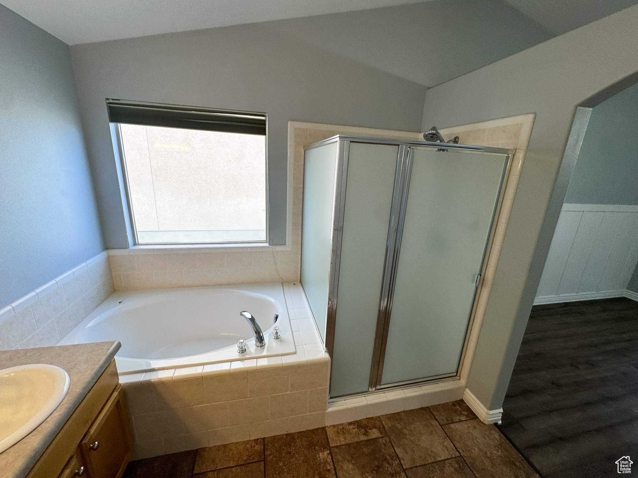 Full bath featuring lofted ceiling, a garden tub, wood finished floors, vanity, and a shower stall
