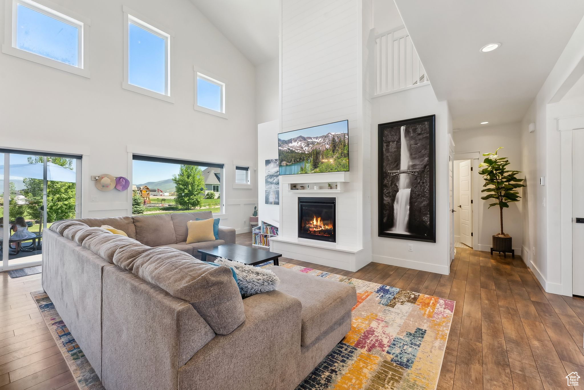 Living room with recessed lighting, baseboards, dark wood finished floors, and a glass covered fireplace