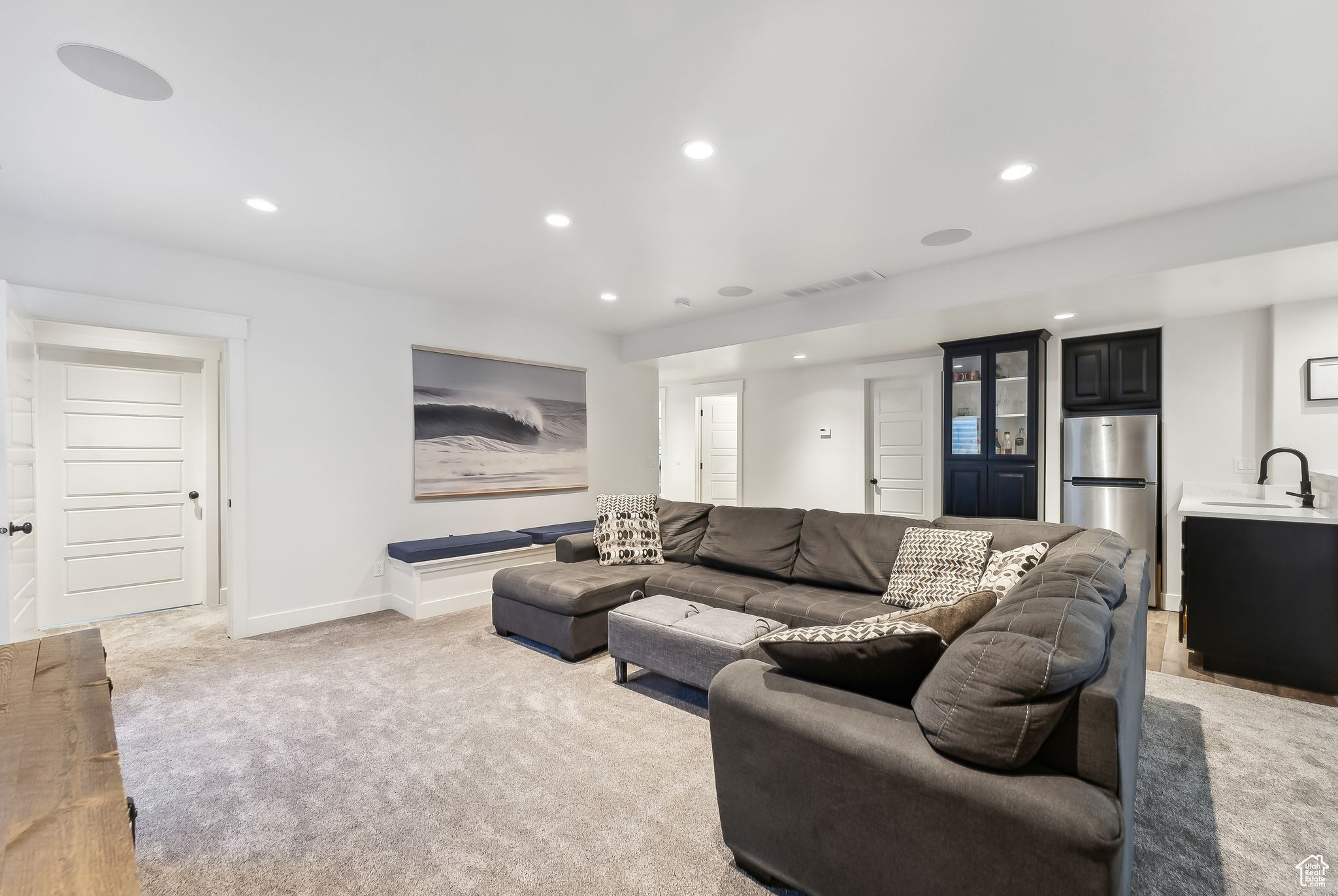 Living area featuring light carpet, baseboards, visible vents, and recessed lighting