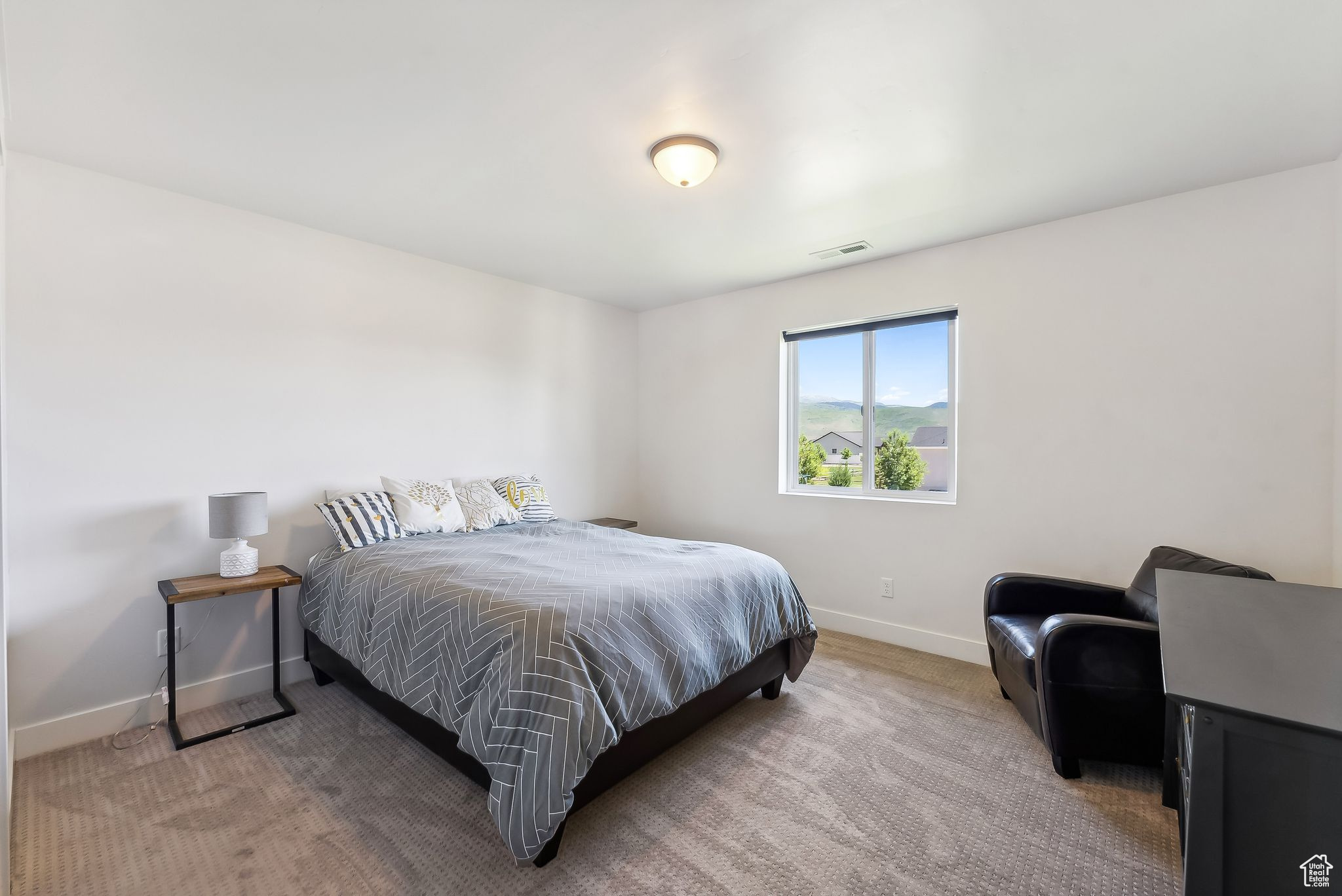 Carpeted bedroom with baseboards and visible vents