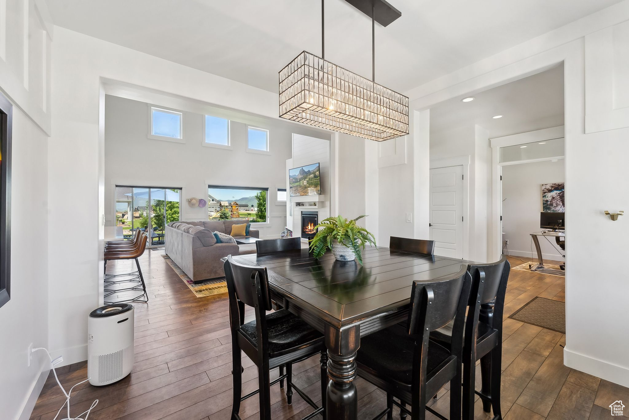 Dining area with dark wood-style floors, a warm lit fireplace, and baseboards