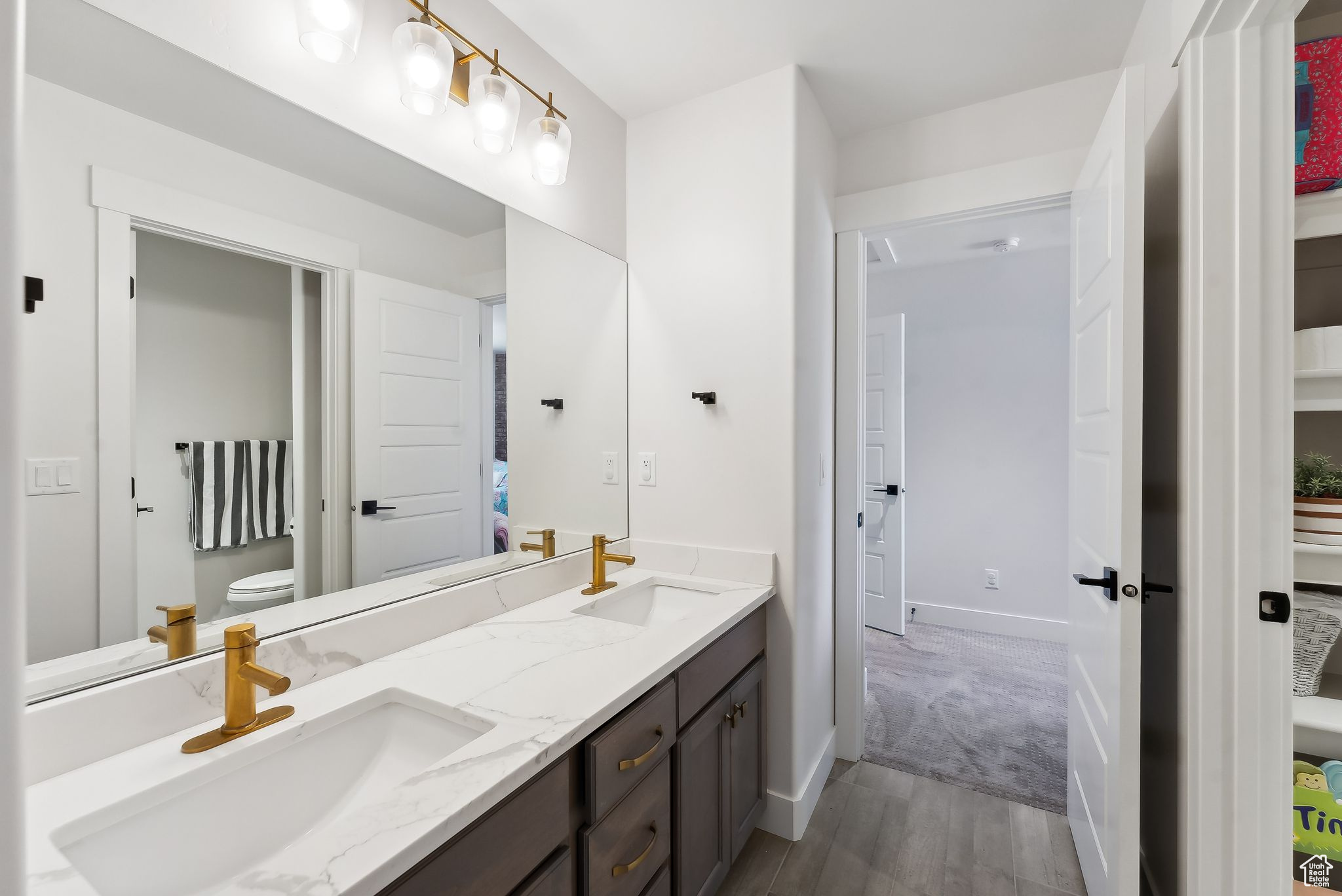 Full bathroom featuring double vanity, toilet, and a sink
