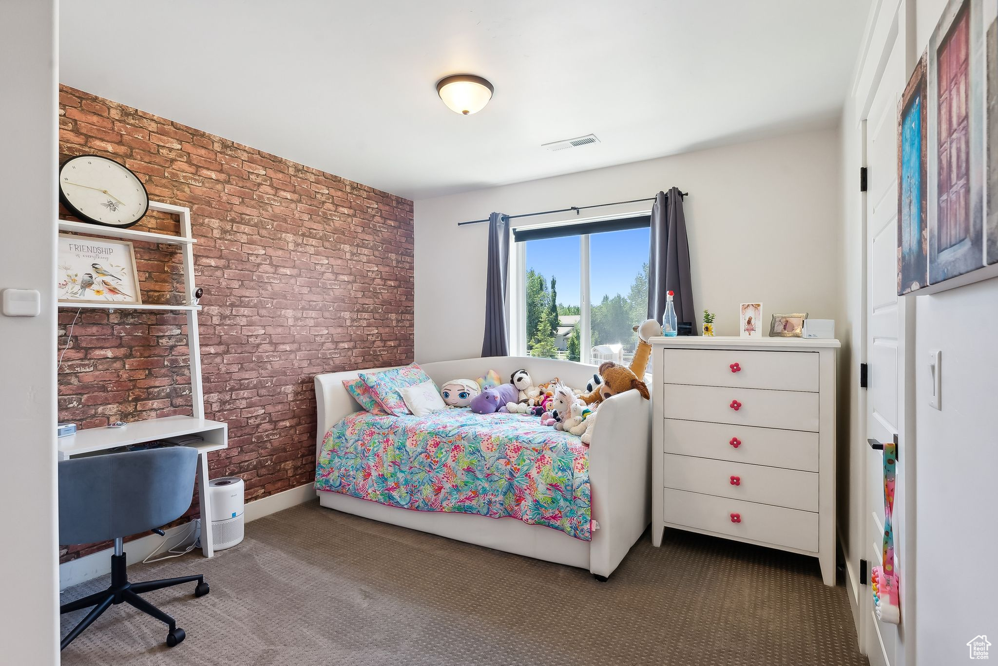 Carpeted bedroom featuring brick wall and visible vents