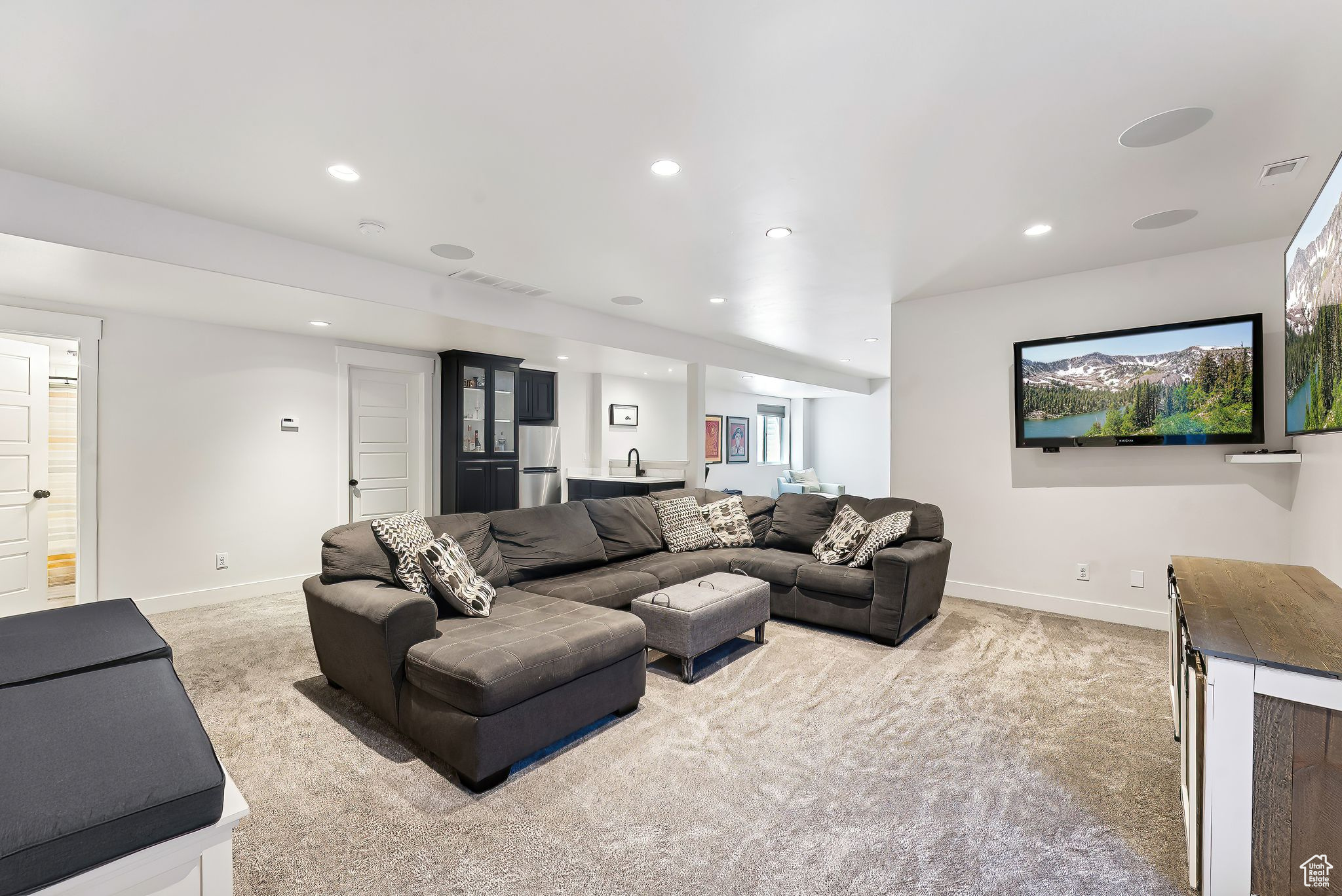 Living room with light carpet, visible vents, and baseboards