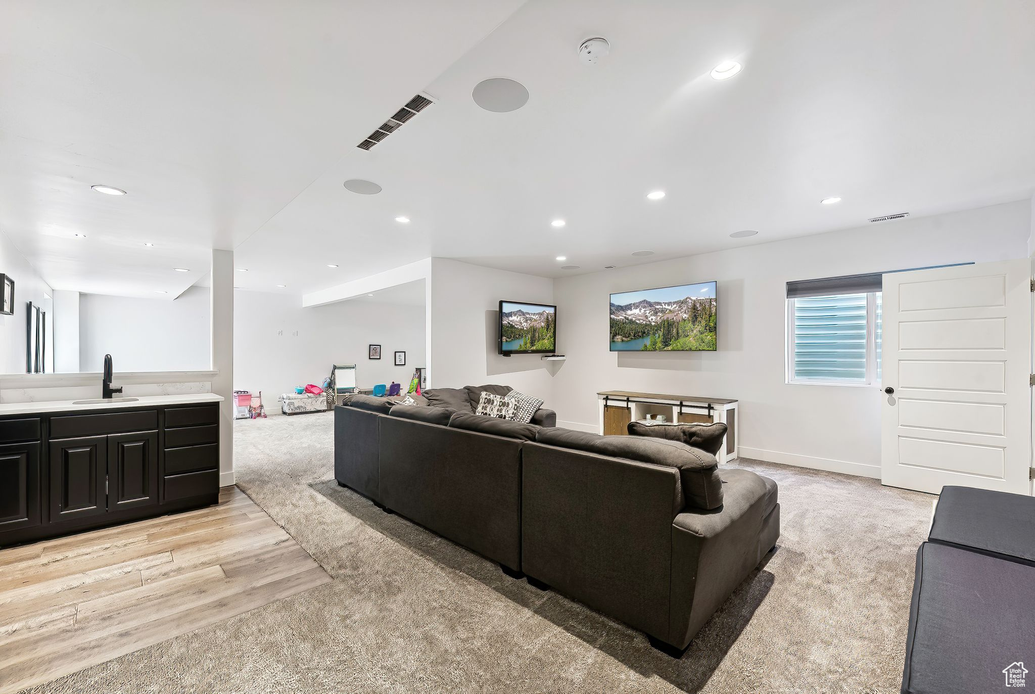 Living area featuring baseboards, light wood-type flooring, visible vents, and recessed lighting