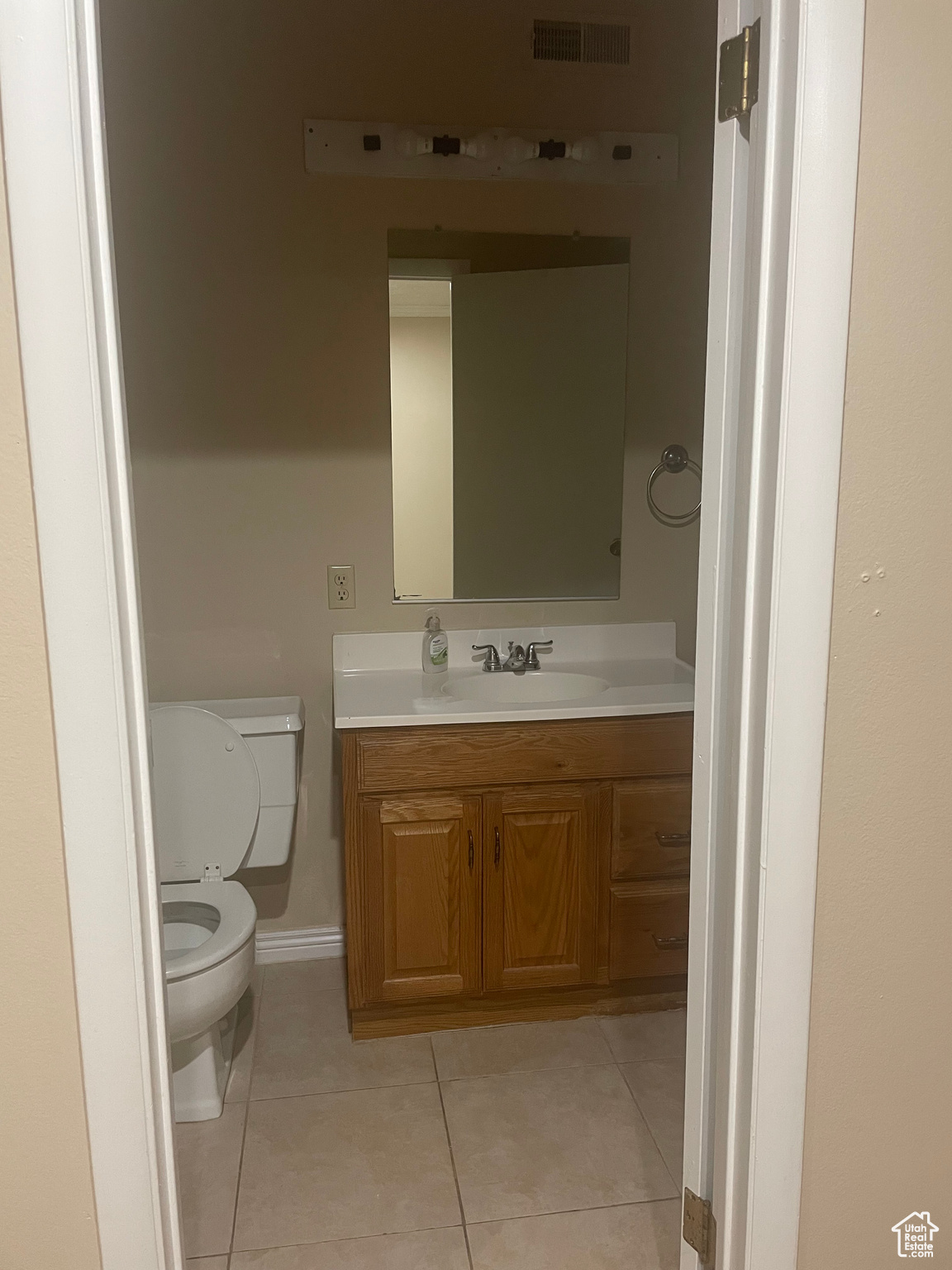 Bathroom featuring toilet, vanity, and tile patterned flooring