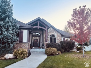 View of front facade with stone siding and a front yard