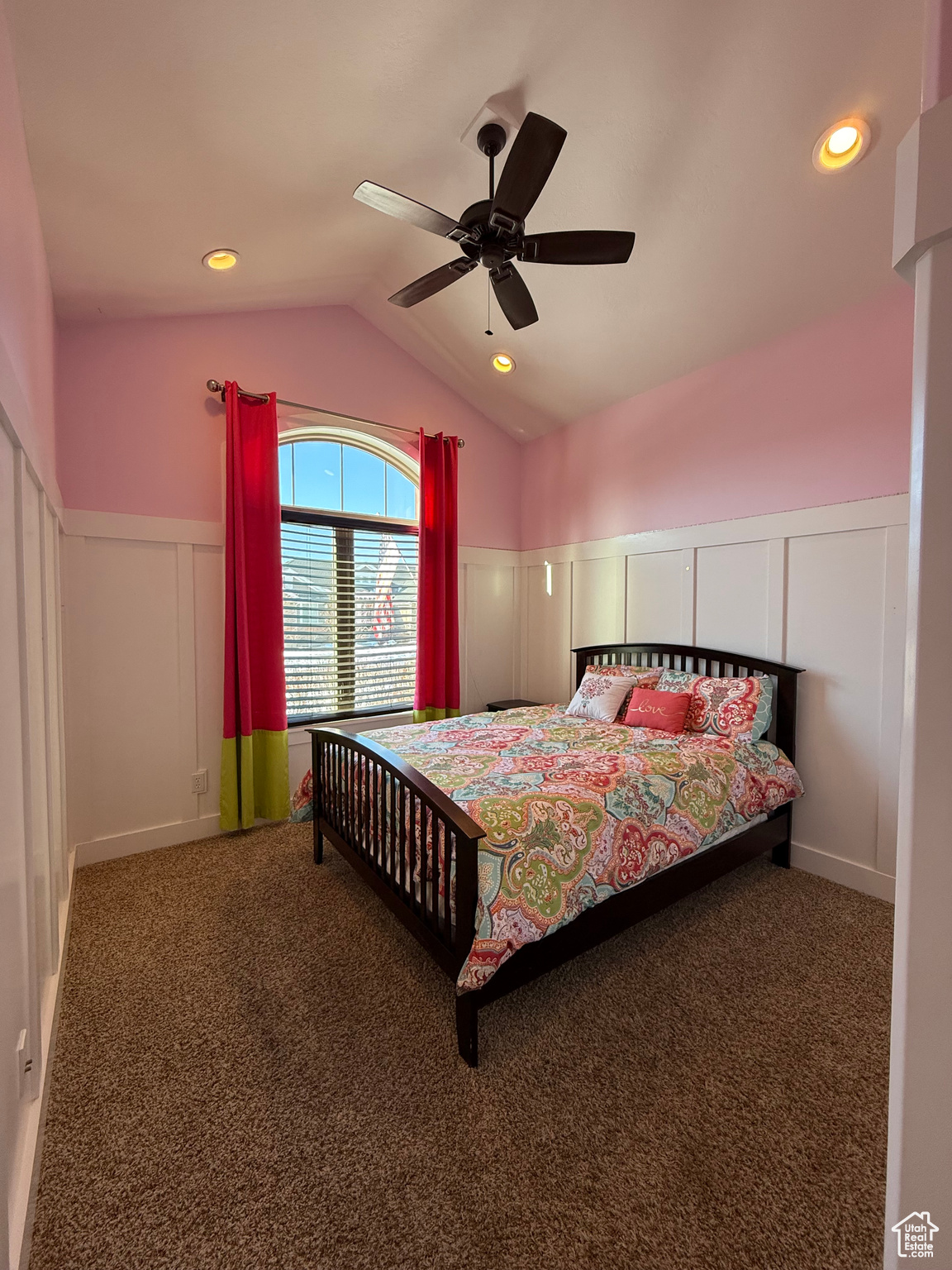 Bedroom featuring a ceiling fan, dark colored carpet, a wainscoted wall, and vaulted ceiling