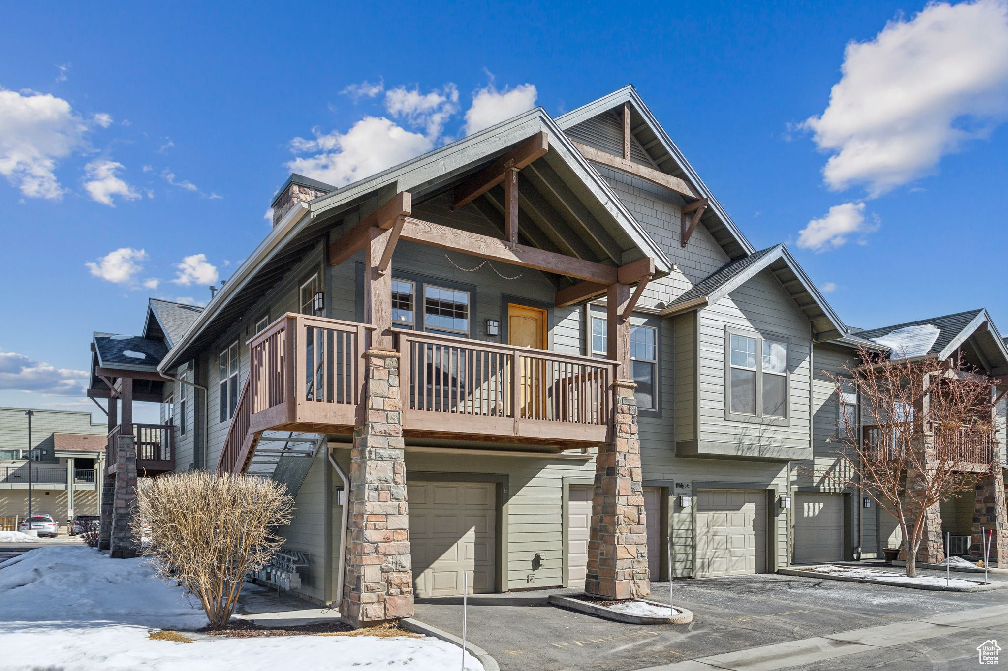 View of front of home featuring a garage and a balcony
