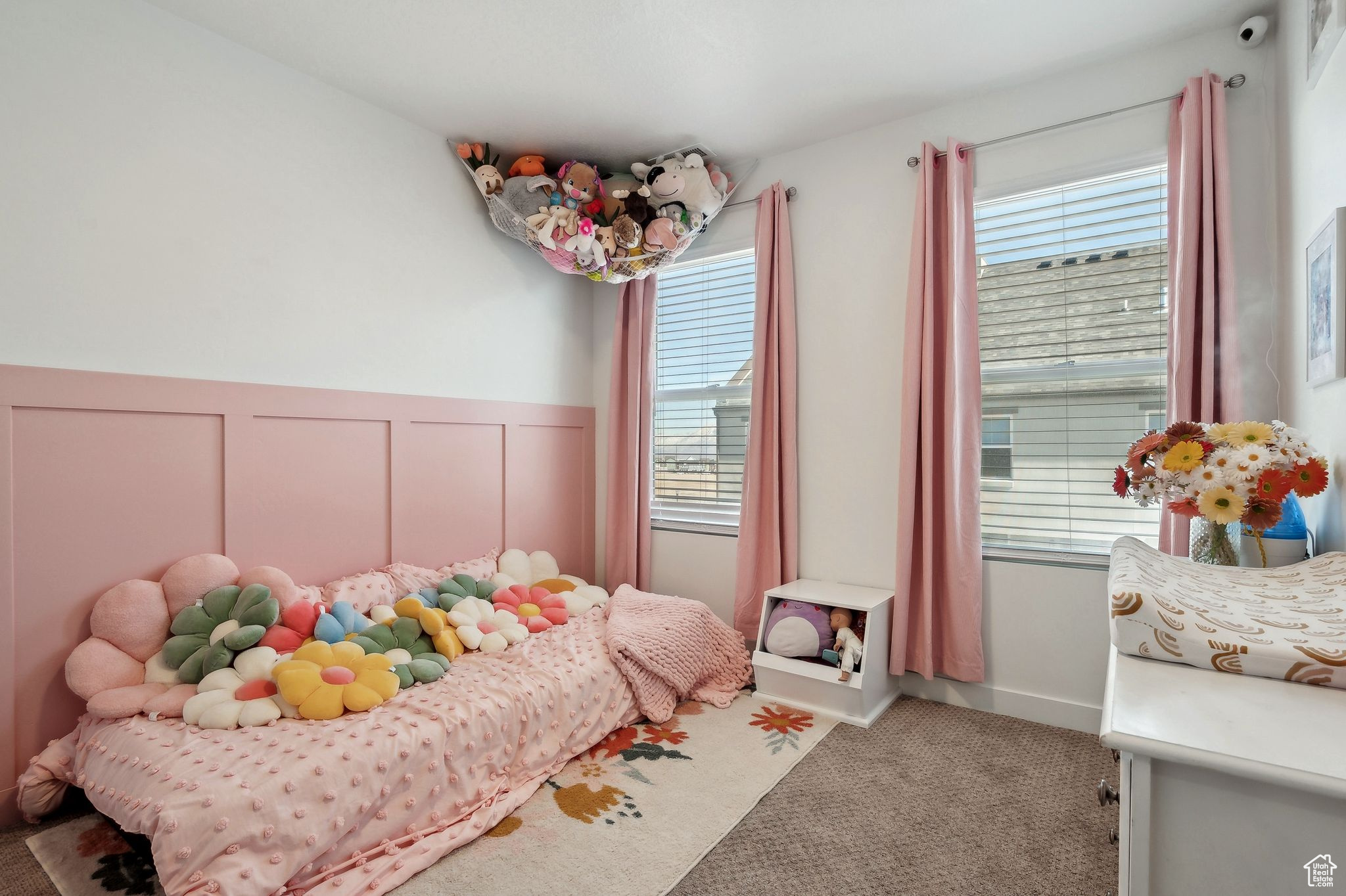 Carpeted bedroom with a wainscoted wall and a decorative wall