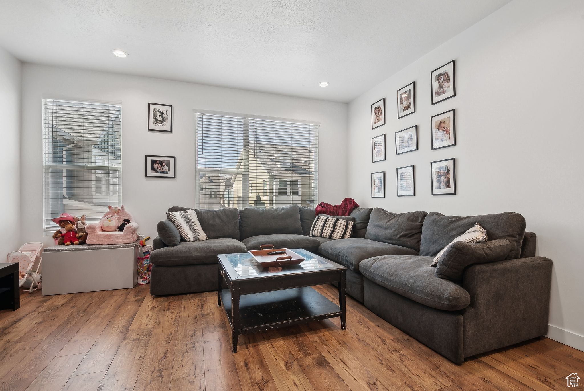 Living area with a textured ceiling, wood finished floors, and recessed lighting