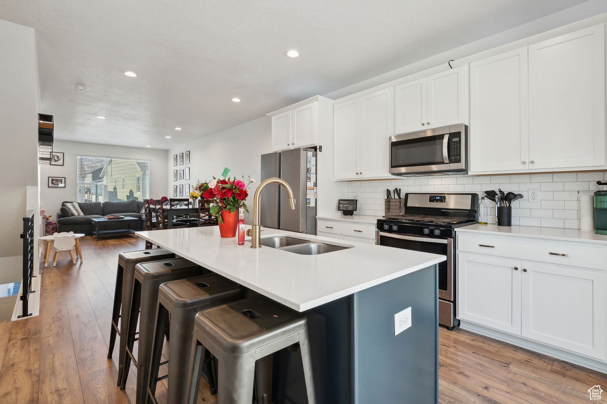 Kitchen with an island with sink, appliances with stainless steel finishes, light countertops, and open floor plan