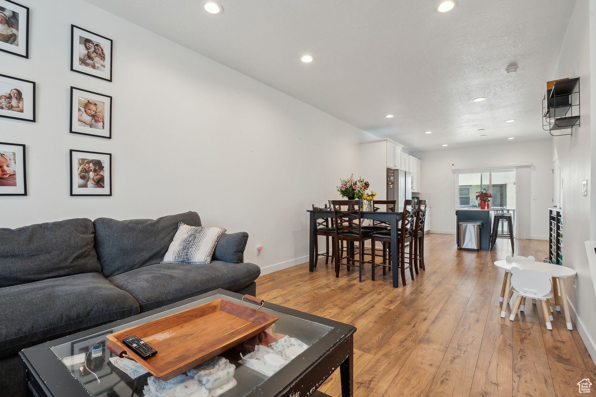 Living area with light wood-style floors, baseboards, and recessed lighting