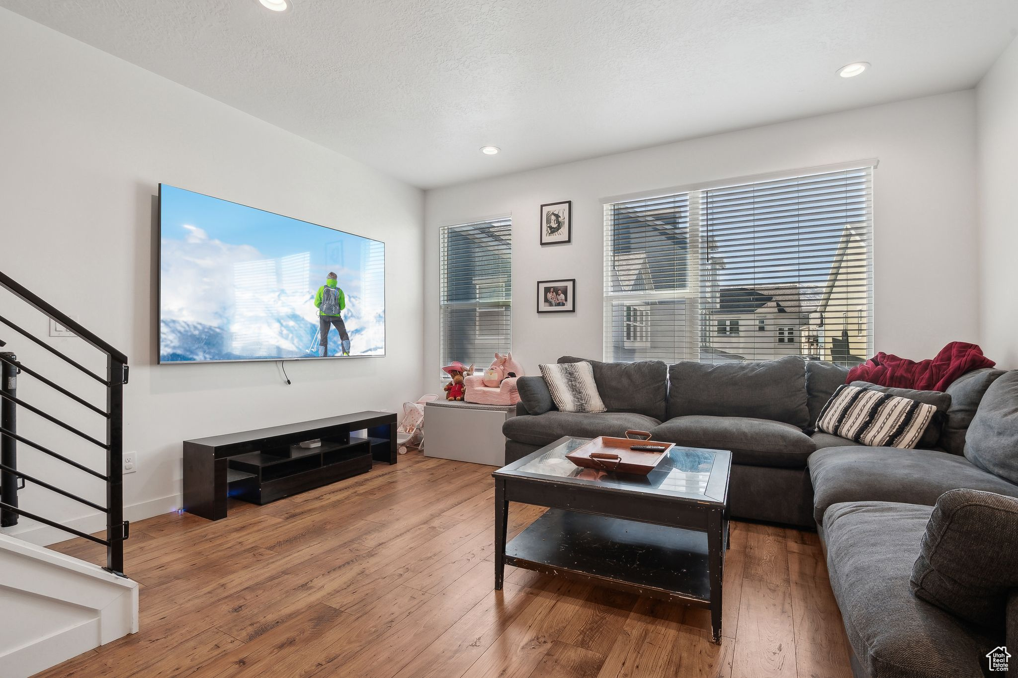 Living room featuring stairs, dark wood-style flooring, a textured ceiling, and recessed lighting