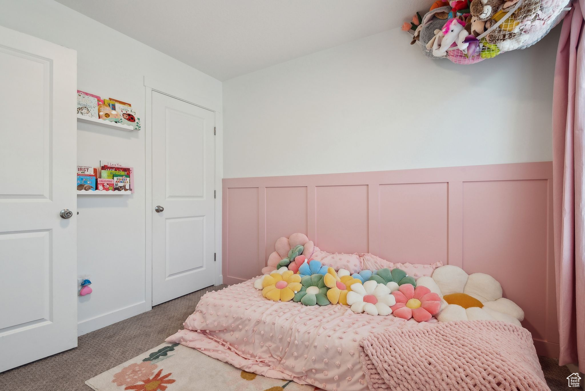 Bedroom with wainscoting, carpet flooring, and a decorative wall