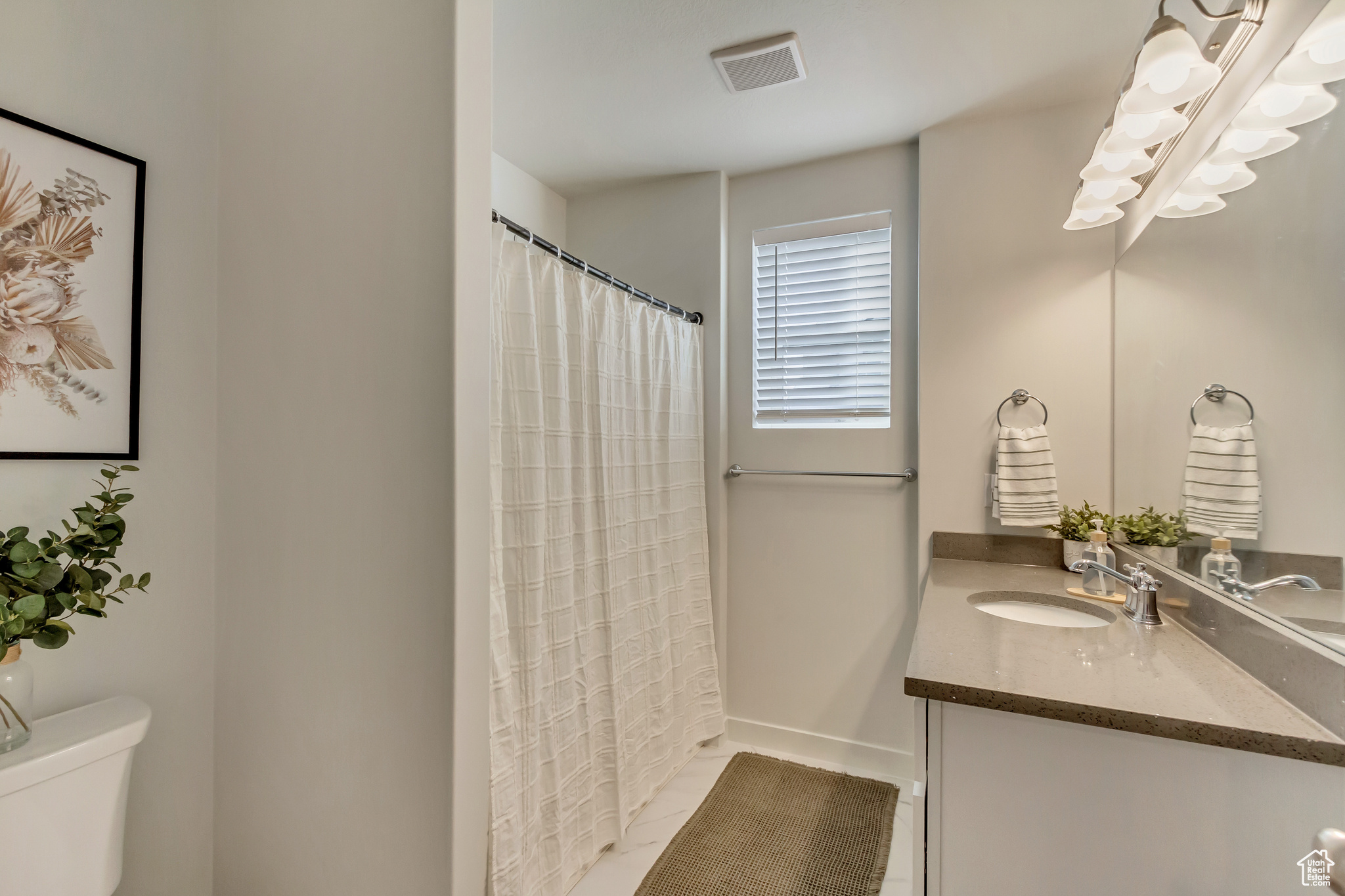 Full bath with toilet, baseboards, visible vents, and vanity