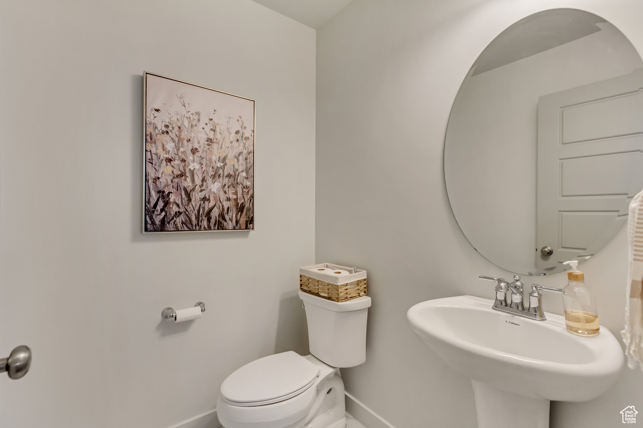 Half bath featuring a sink, toilet, and baseboards