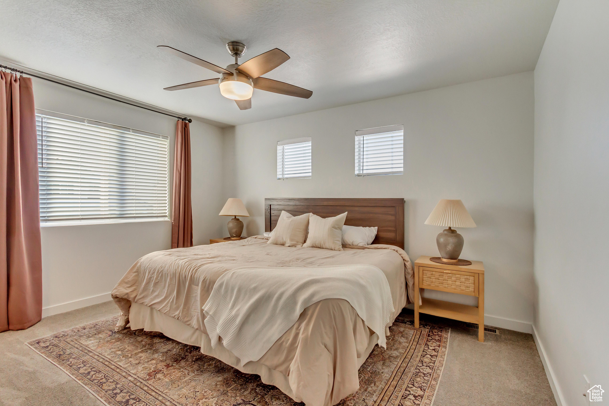 Carpeted bedroom featuring ceiling fan and baseboards