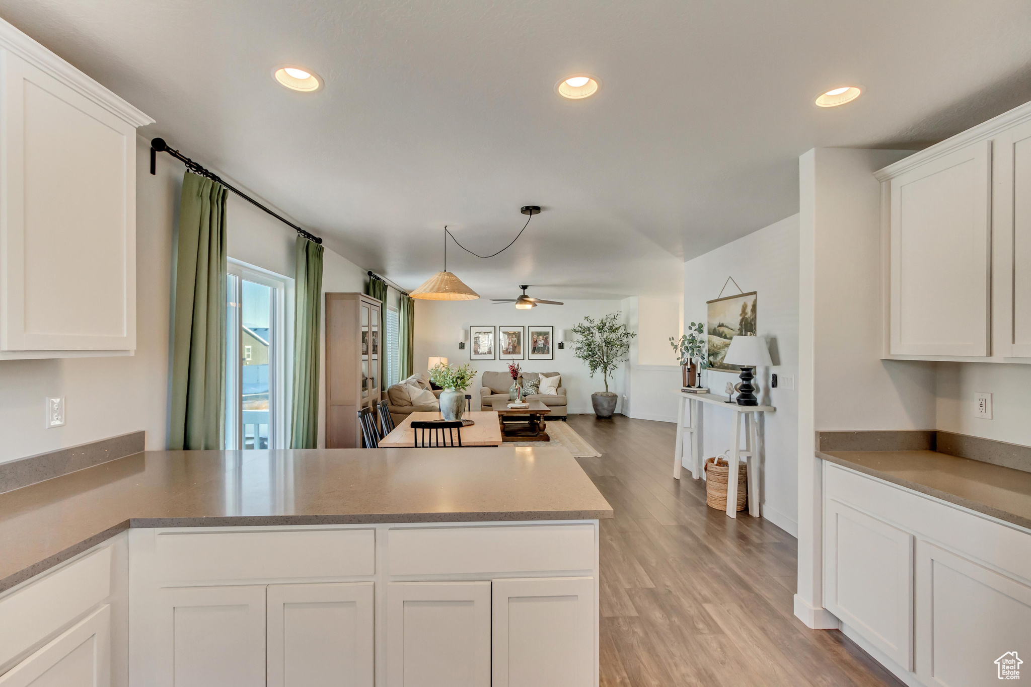 Kitchen featuring light wood-style floors, recessed lighting, open floor plan, and white cabinets