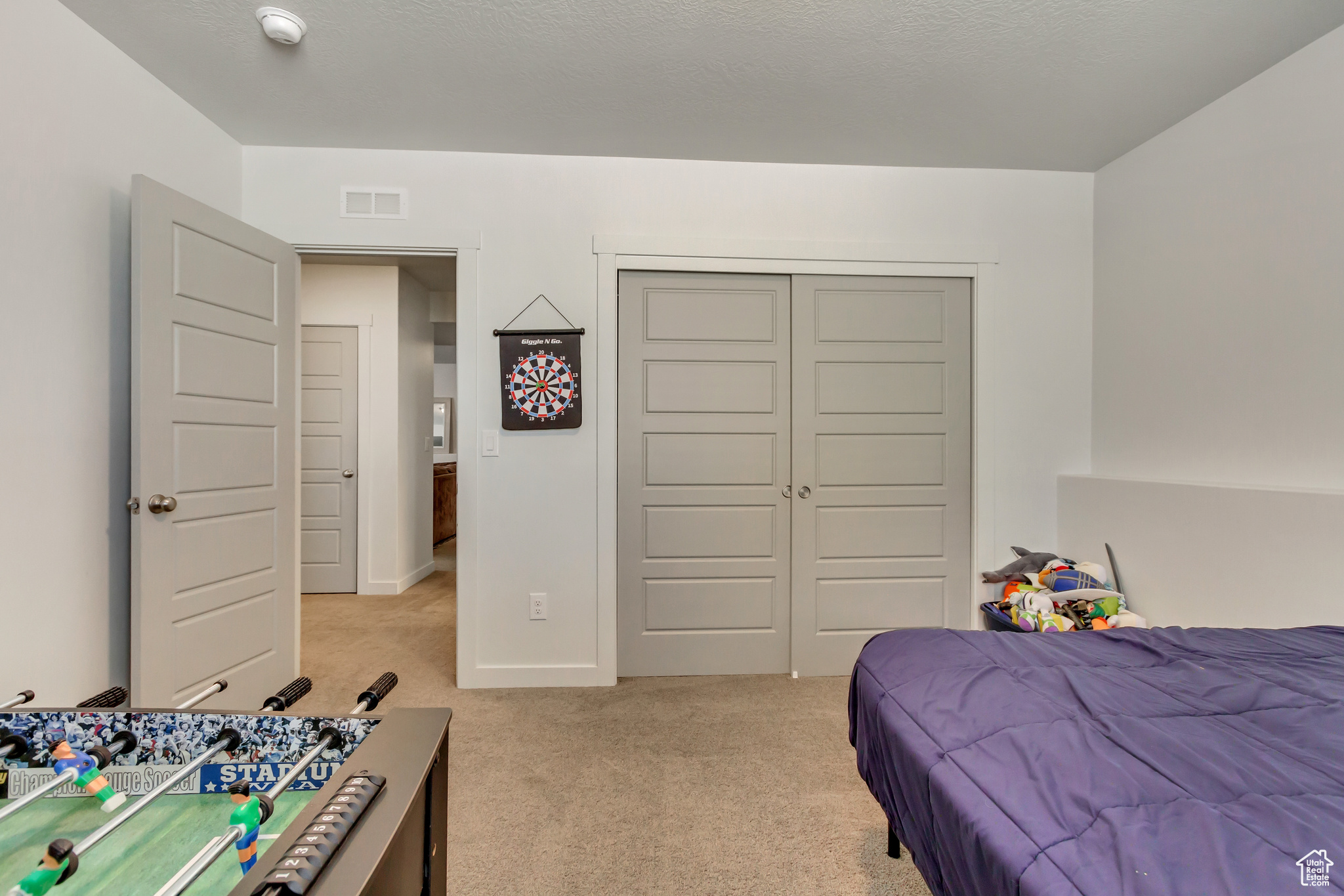Bedroom with baseboards, visible vents, a closet, and light colored carpet