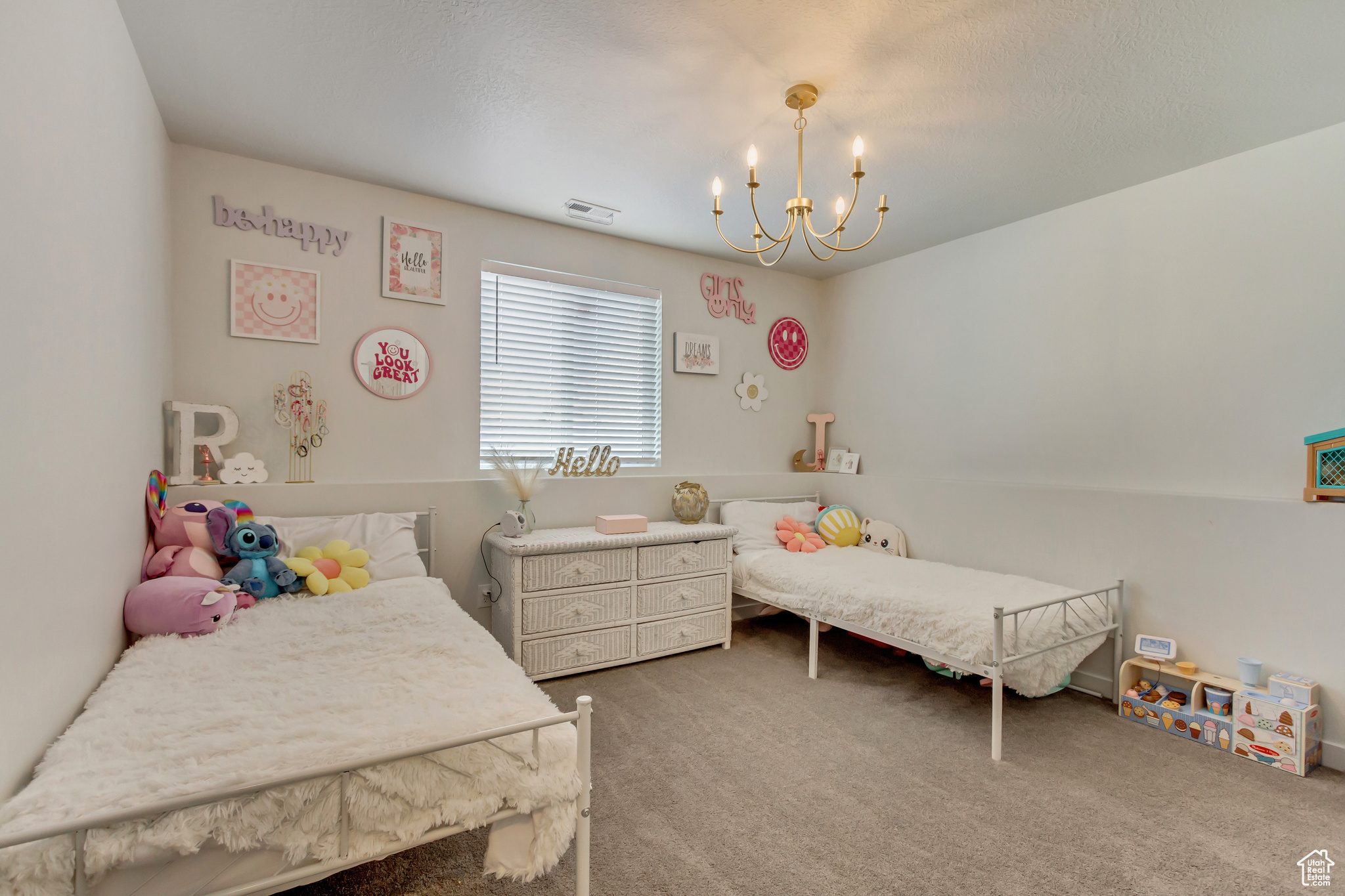 Bedroom with carpet floors, visible vents, and a notable chandelier