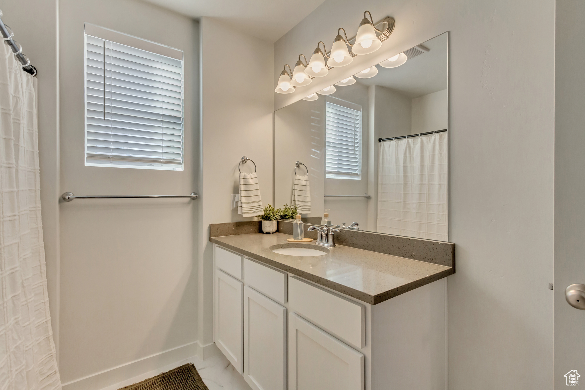 Full bathroom featuring vanity and baseboards