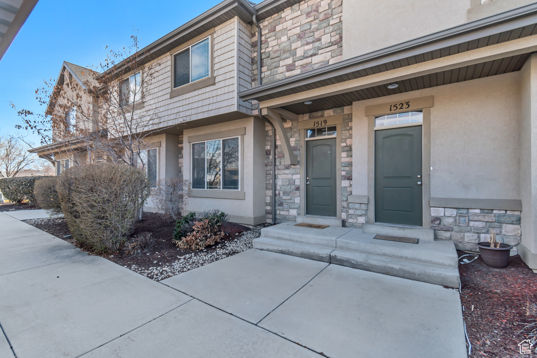 View of exterior entry featuring stone siding and stucco siding