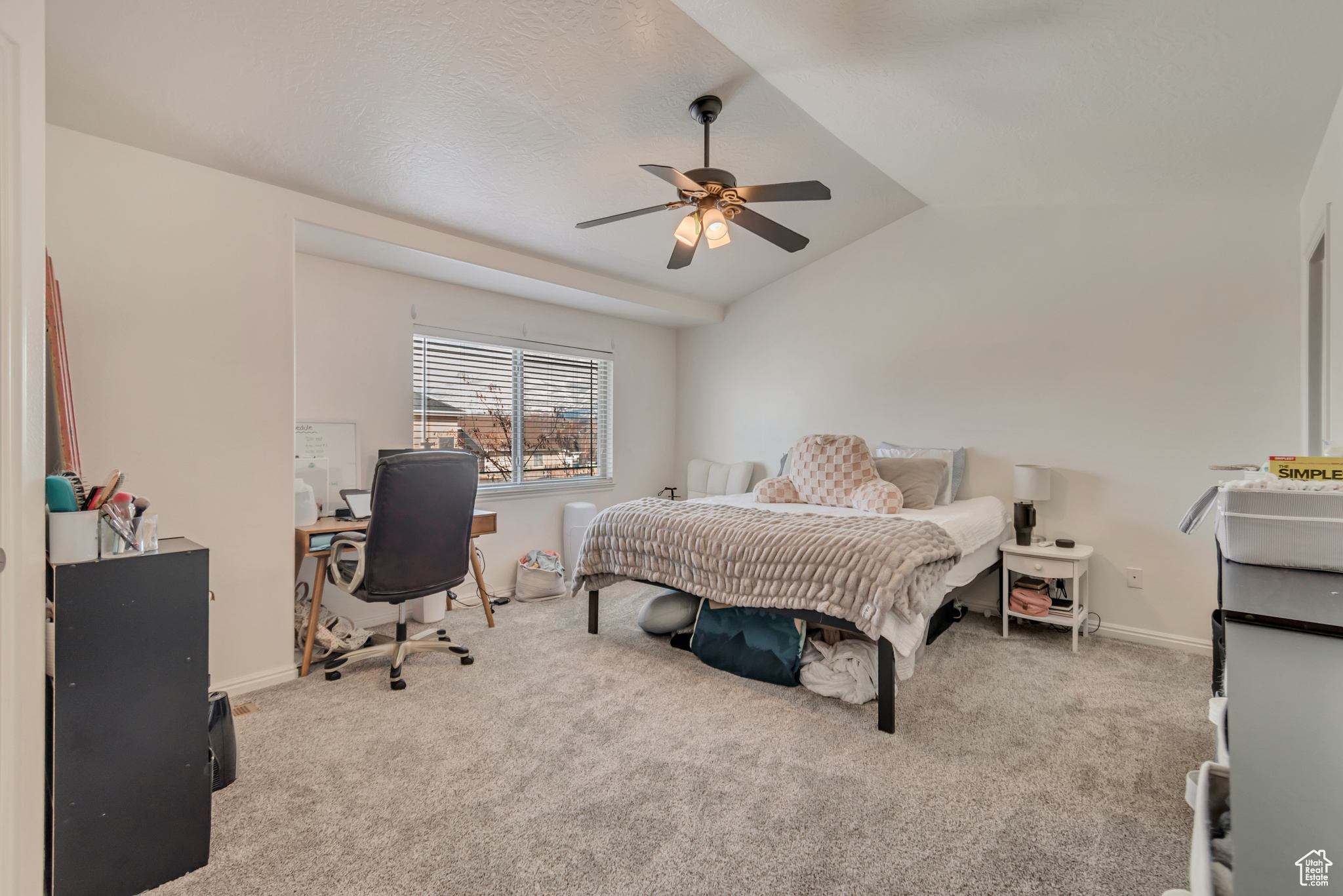 Primary bedroom featuring ceiling fan and lofted ceiling