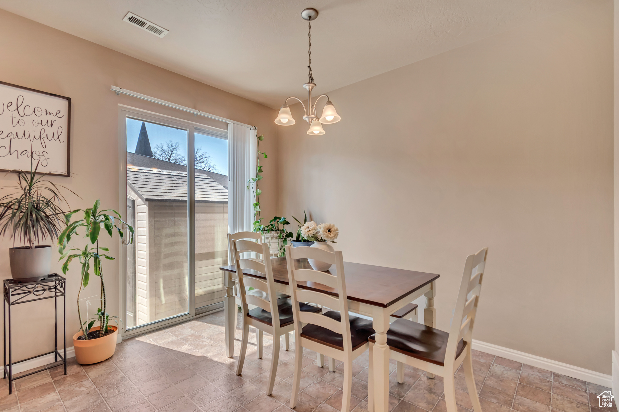 Dining room featuring sliding glass door to back patio and a chandelier