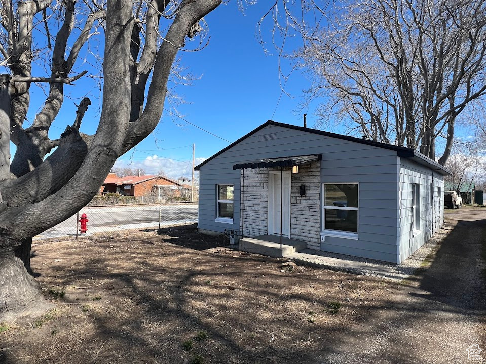 View of front facade with stone siding and fence