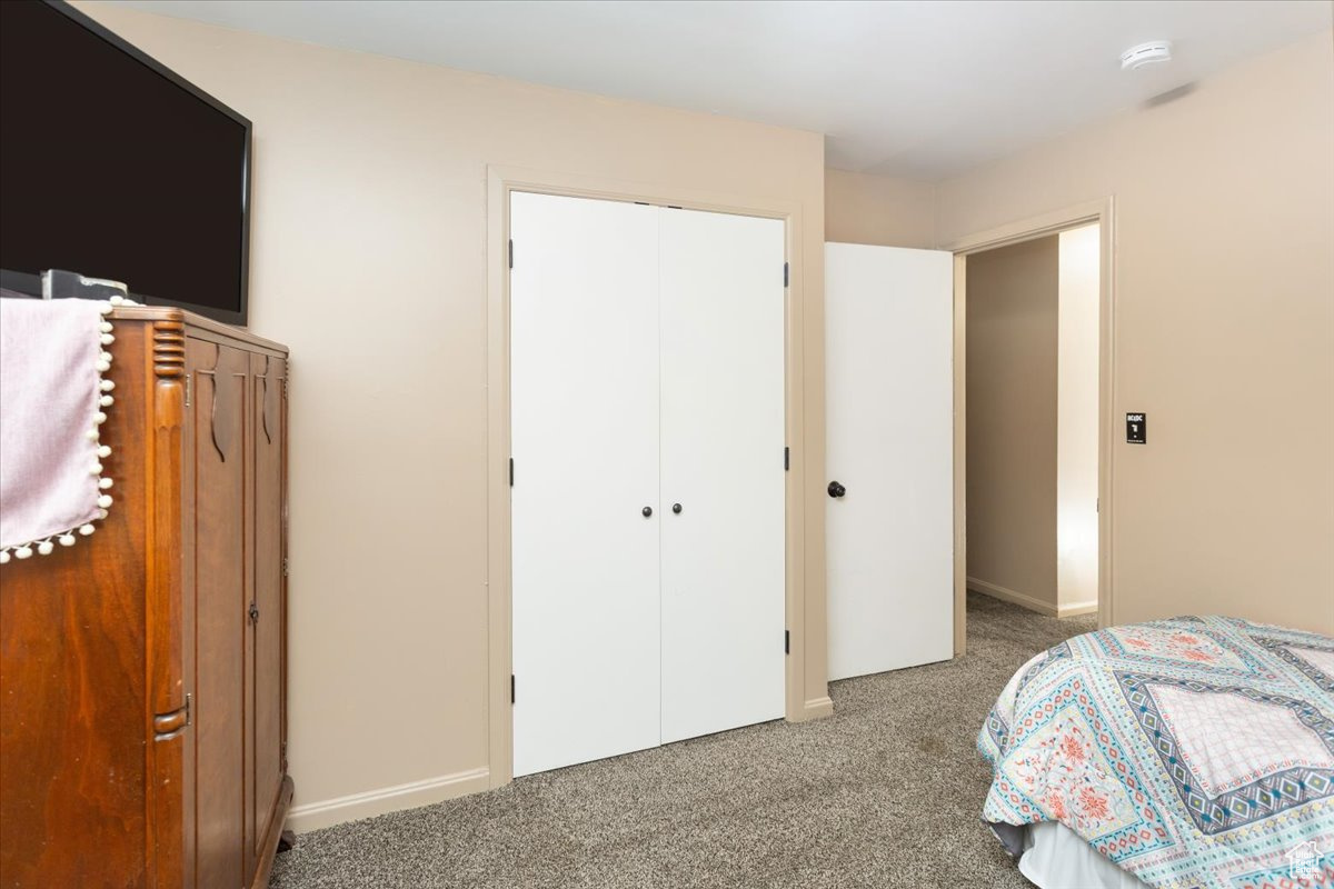 Bedroom featuring light colored carpet and a closet