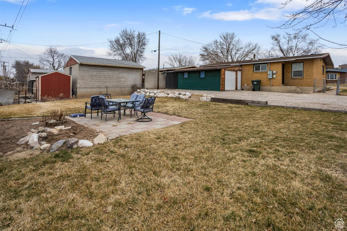 View of yard with an outbuilding, a patio area, and fence