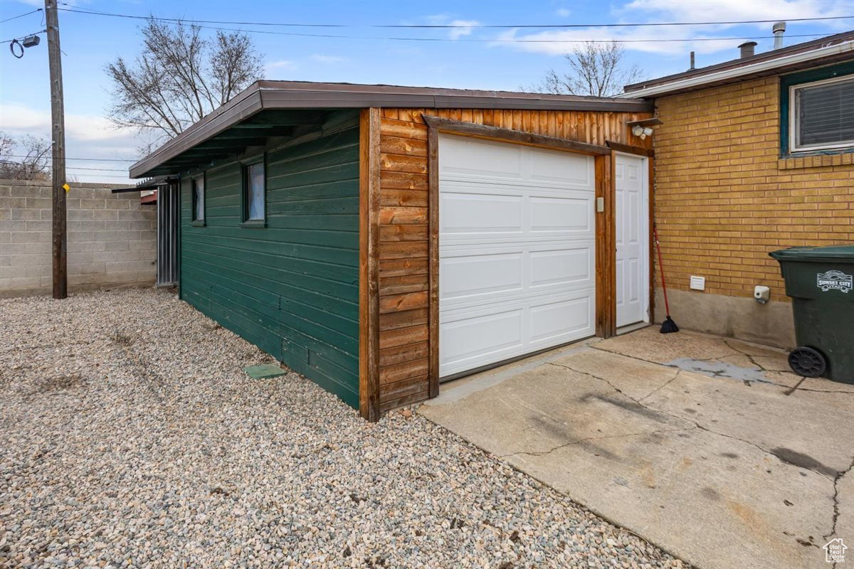 Garage featuring driveway and fence